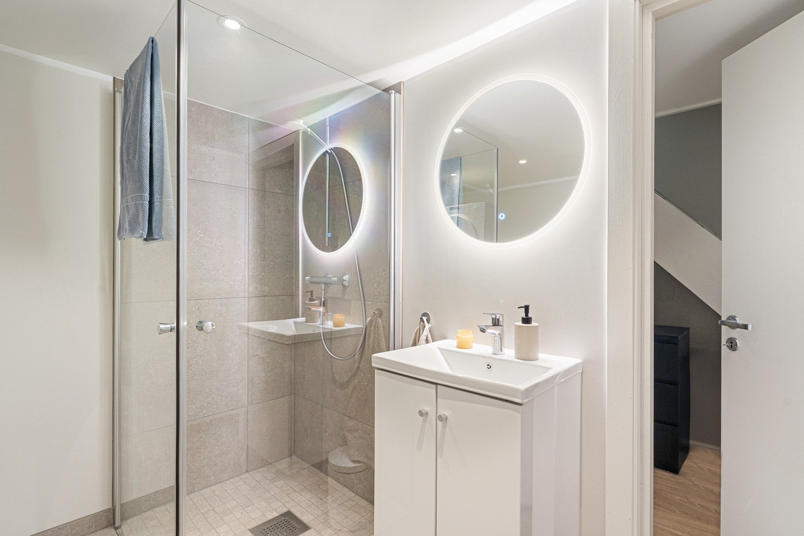 Badet er utstyrt med dusjhjørne, servant i skap, toalett og opplegg til vaskemaskin. Galleribilde