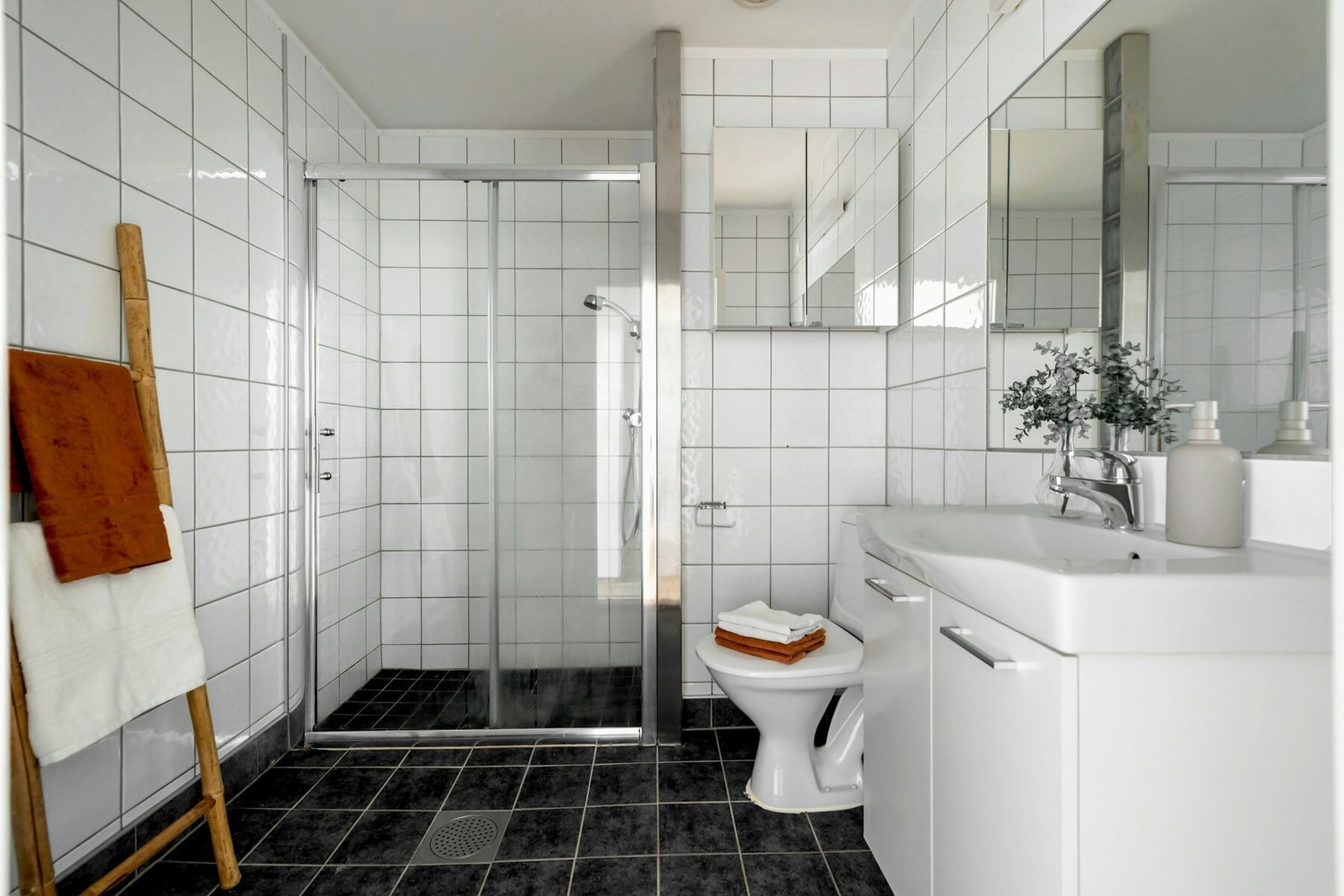 Leiligheten har et flislagt bad med dusjkabinett og toalett Galleribilde