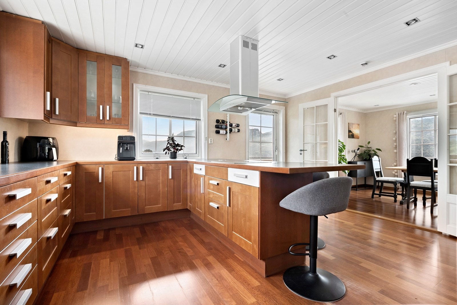 Flott, stort kjøkken med fronter i kirsebær. Kjøkkenøy med spiseplasser og platetopp Galleribilde