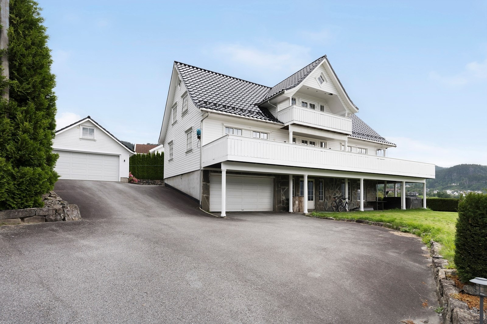 Fasade - To doble garasjer. Elbil-lader i husgarasje. Romslig asfaltert tun Galleribilde