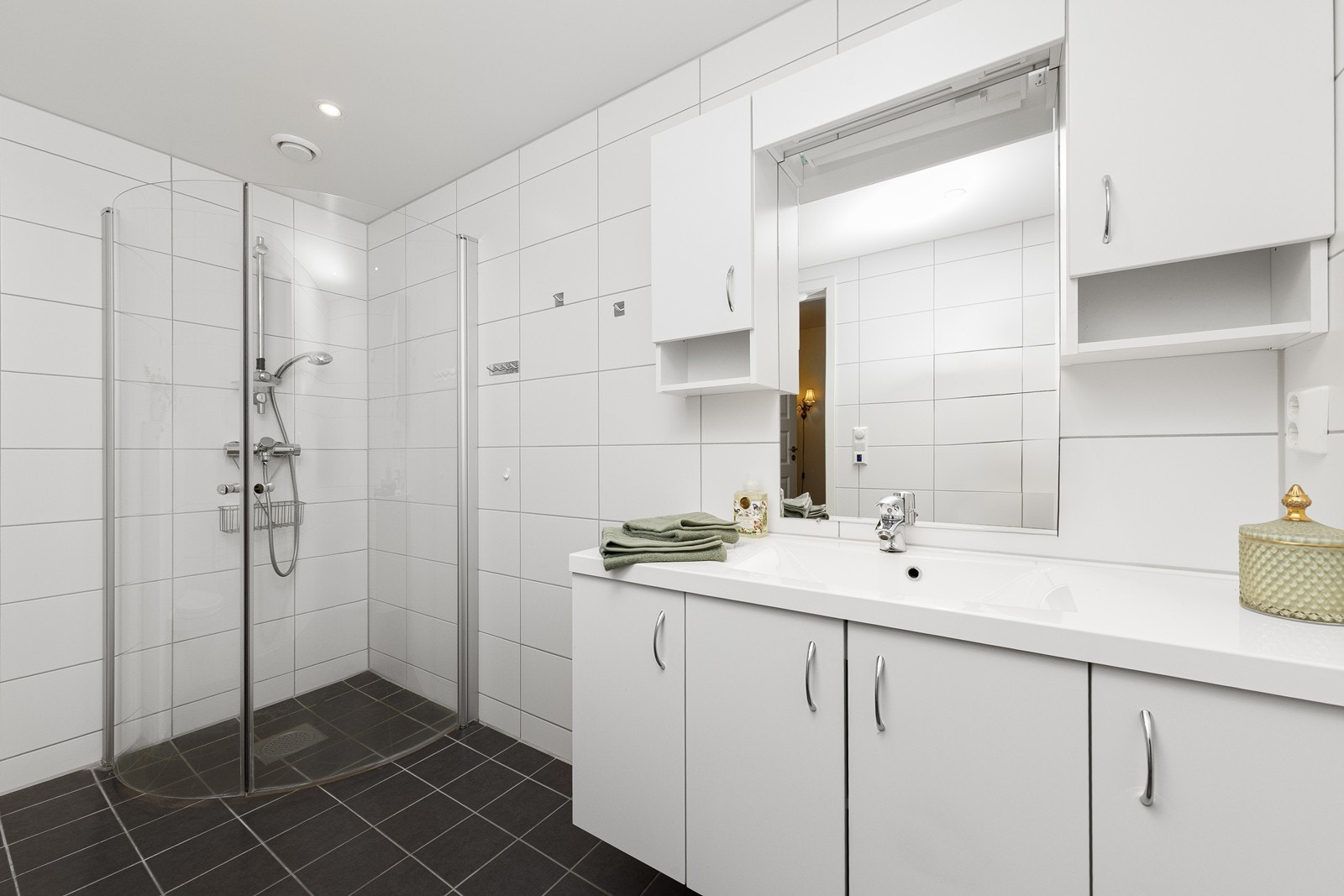 Innredningen består av en nedfelt servant, veggmontert toalett og dusjvegger i hjørneløsning. Galleribilde