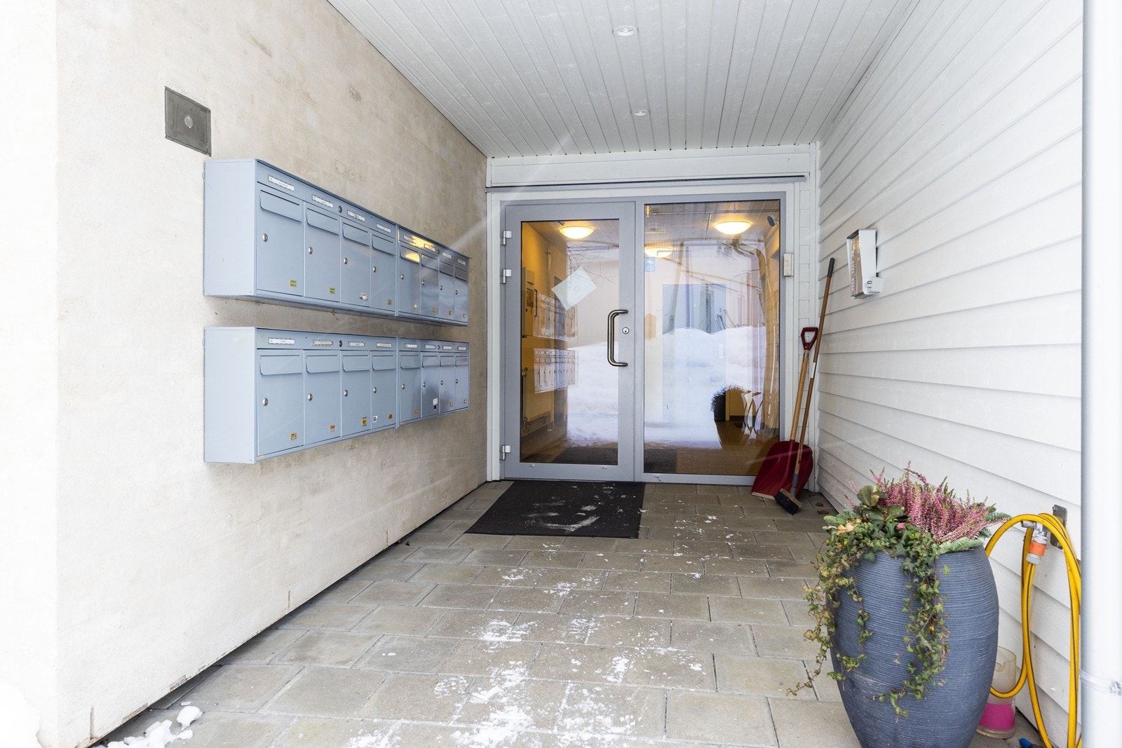 Man ønskes velkommen via et felles overbygd inngangsparti. Galleribilde