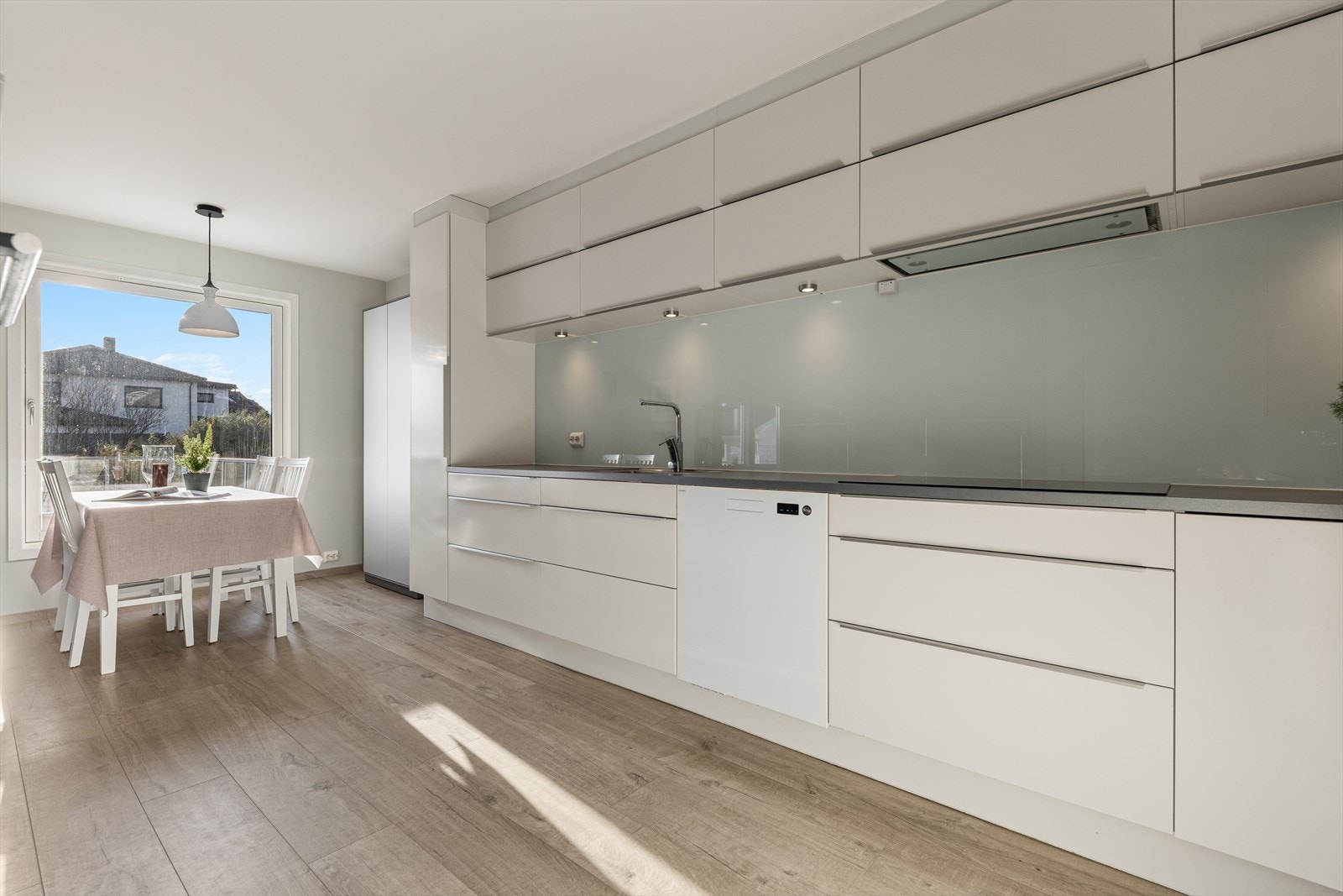 Store vindusflater gir naturlig lys til spiseplassen ved kjøkkenet. Galleribilde