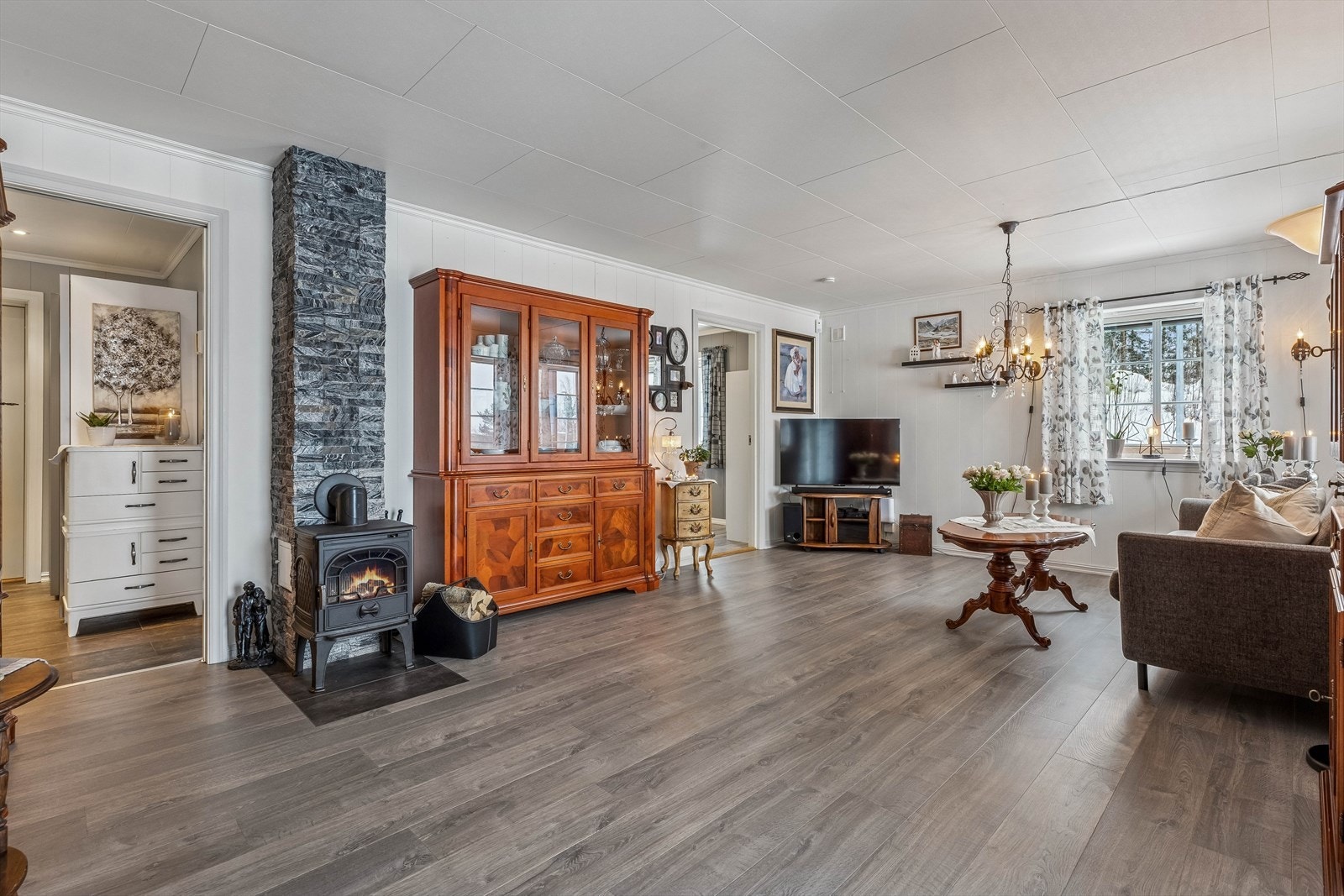 Stuen er romslig og har en peis for vedfyring som gir ekstra varme og hygge. Galleribilde