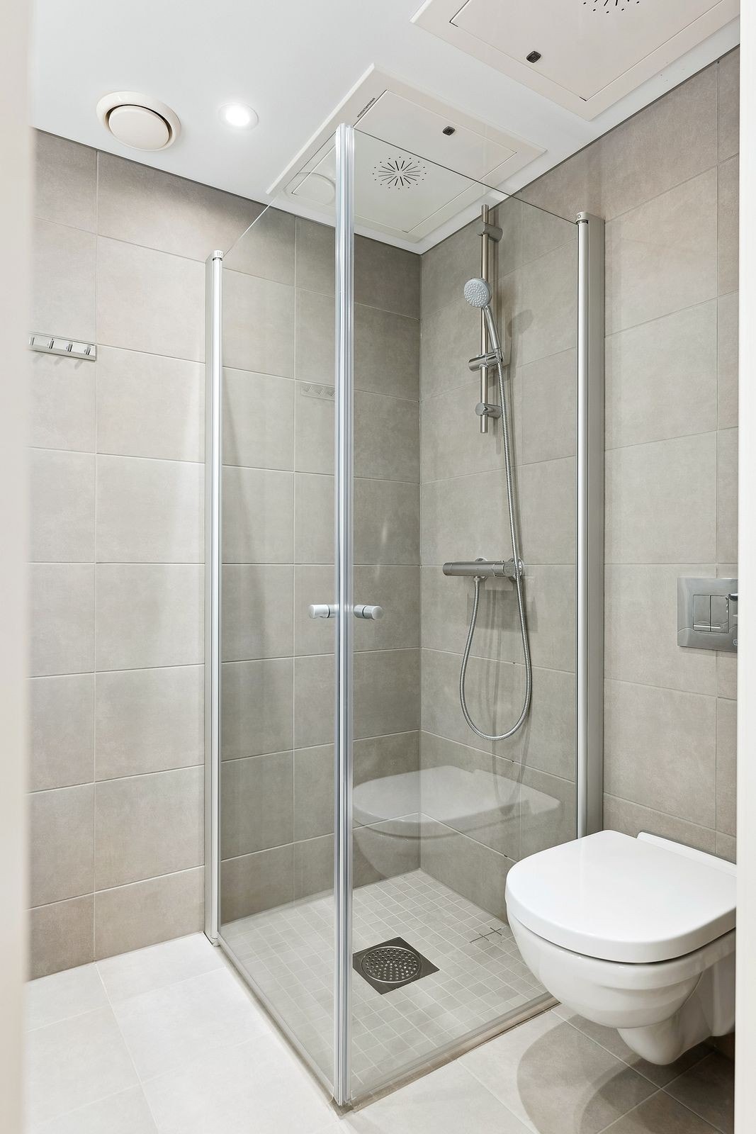 Lekkert flislagt bad med innfellbare dusjdører Galleribilde