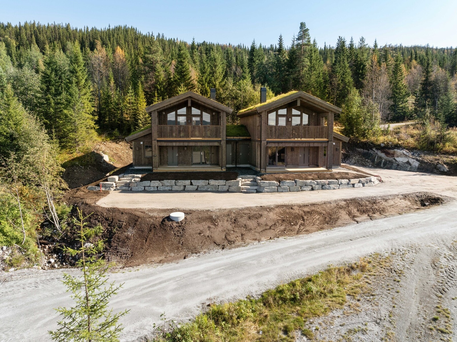 Glimmervegen 6A utgjør en halvpart av en tomannsbolig fra 2024 - likevel fullt og helt sin egen hytte med private uteplasser, og boder som skiller de ulike enhetene. Galleribilde