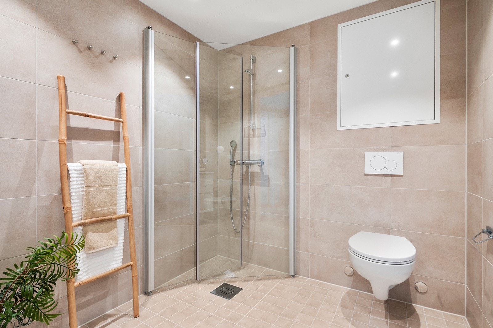 Delikat flislagt beige bad med varmekabler i gulv og downlights med dimmer i himling. Galleribilde