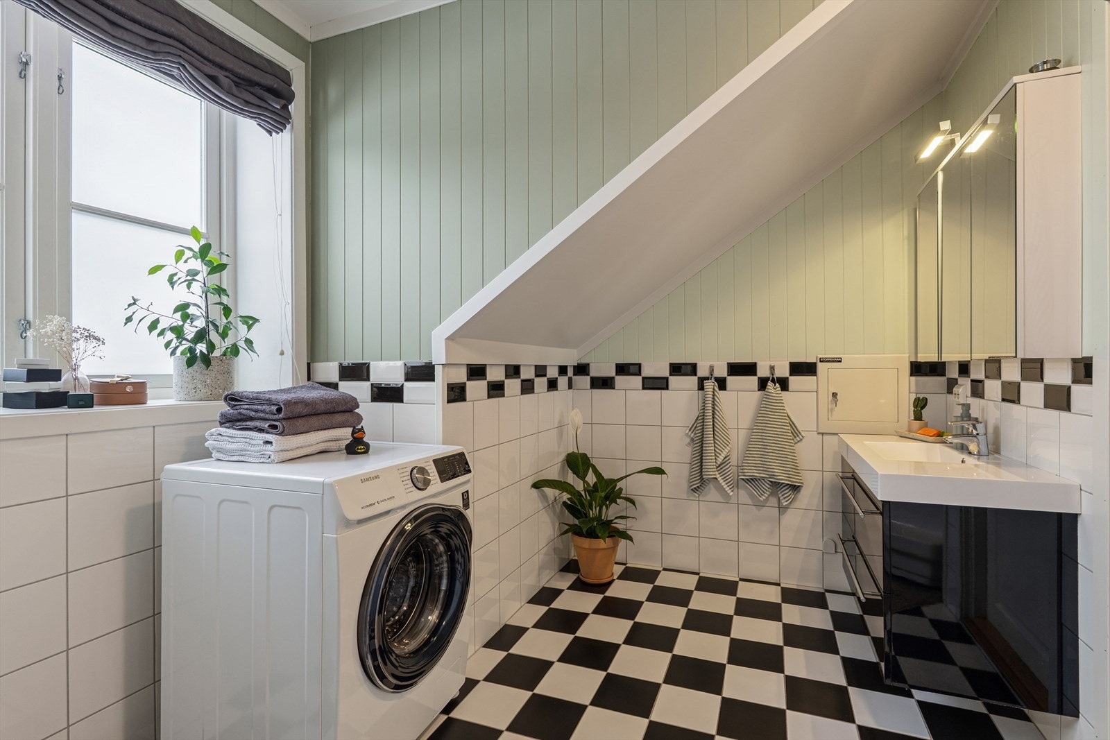 På badet er det dusjkabinett, baderomsinnredning og toalett.
Opplegg for vaskemaskin. Galleribilde