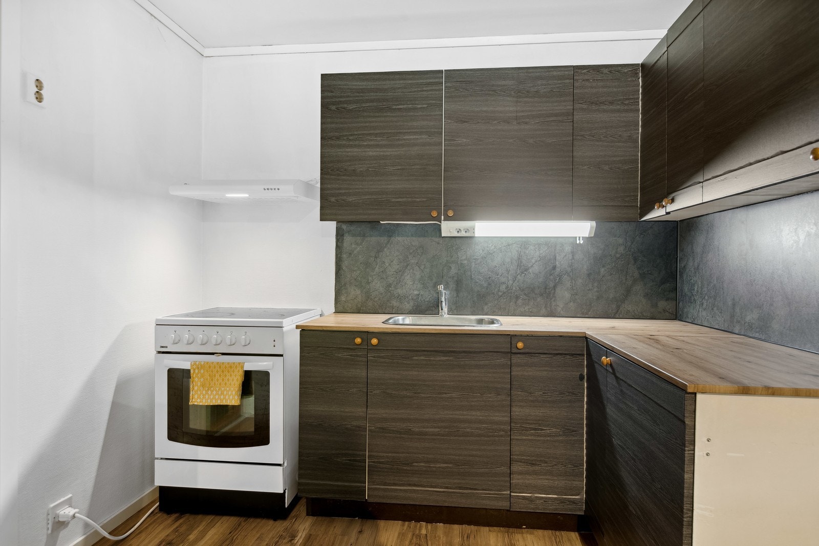 Kjøkken med frittstående komfyr og kjøleskap. Galleribilde