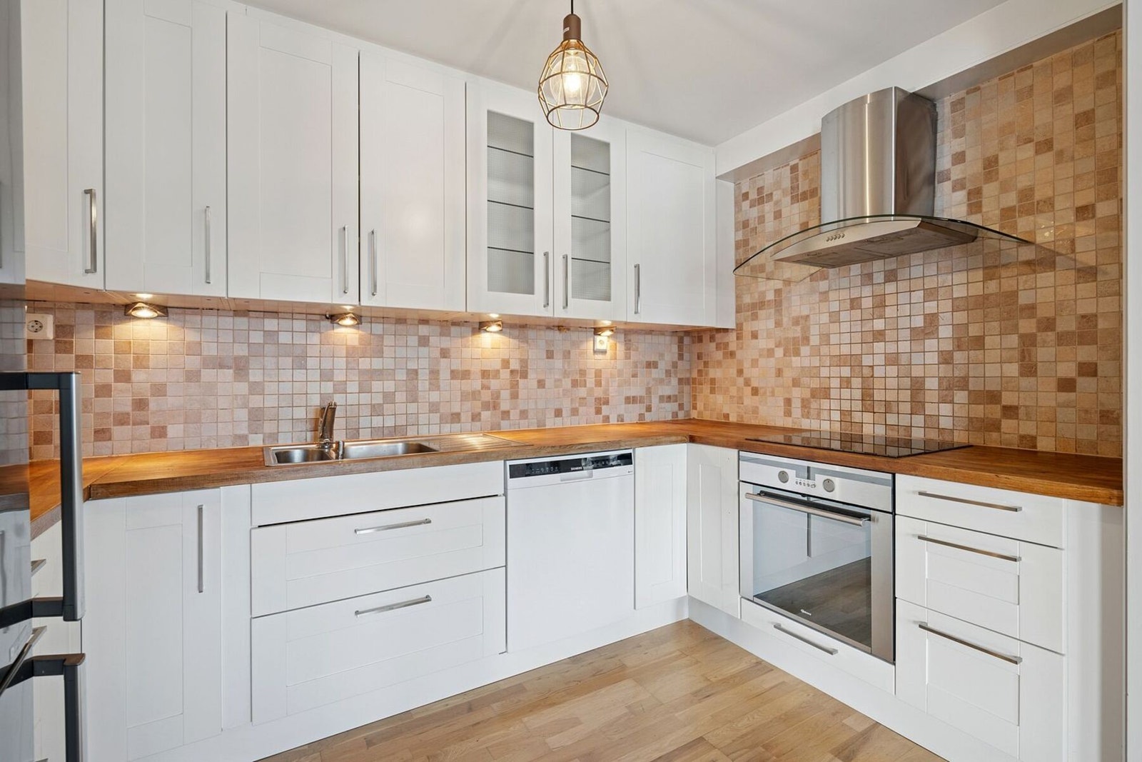 Kjøkken - innredningen har benkeplate av heltre, kjøl/fryseskap, oppvaskmaskin, platetopp og stekeovn Galleribilde