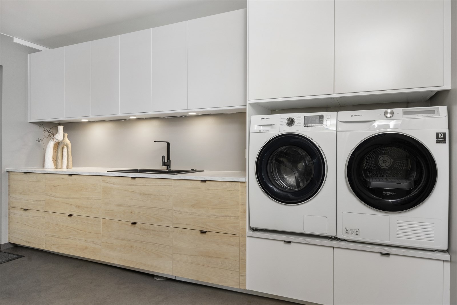 Separat vaskerom med praktiske løsninger som benkeplate, opplegg for vaskemaskin og tørketrommel samt direkte inngang fra garasjen. Galleribilde