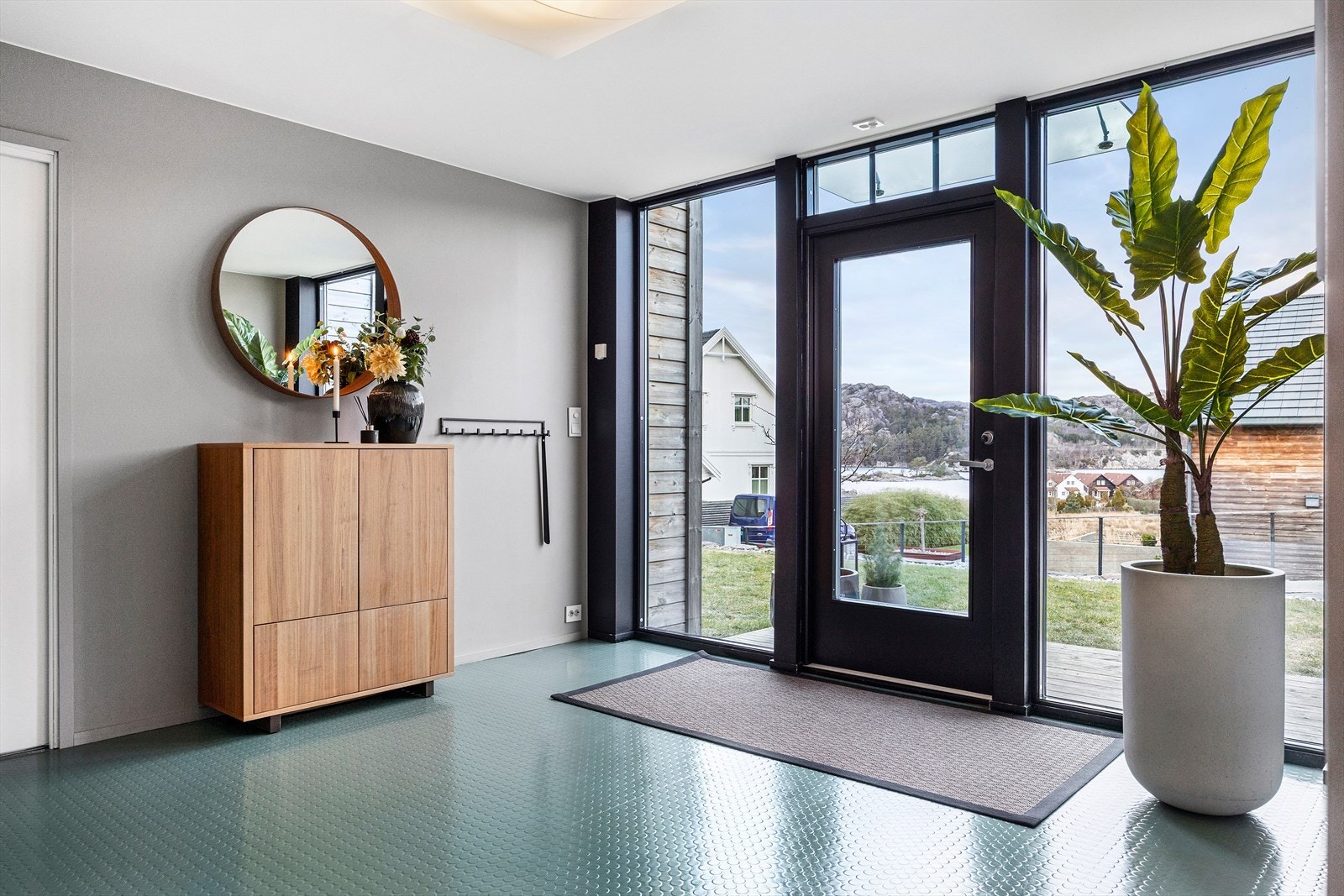 Lys og romslig entré/hall som ønsker deg velkommen med stil. Med god plass til oppbevaring av yttertøy og sko er det enkelt å holde det ryddig. Når du entrer denne boligen, får du umiddelbart en følelse av romslighet og gjennomtenkte løsninger. Galleribilde