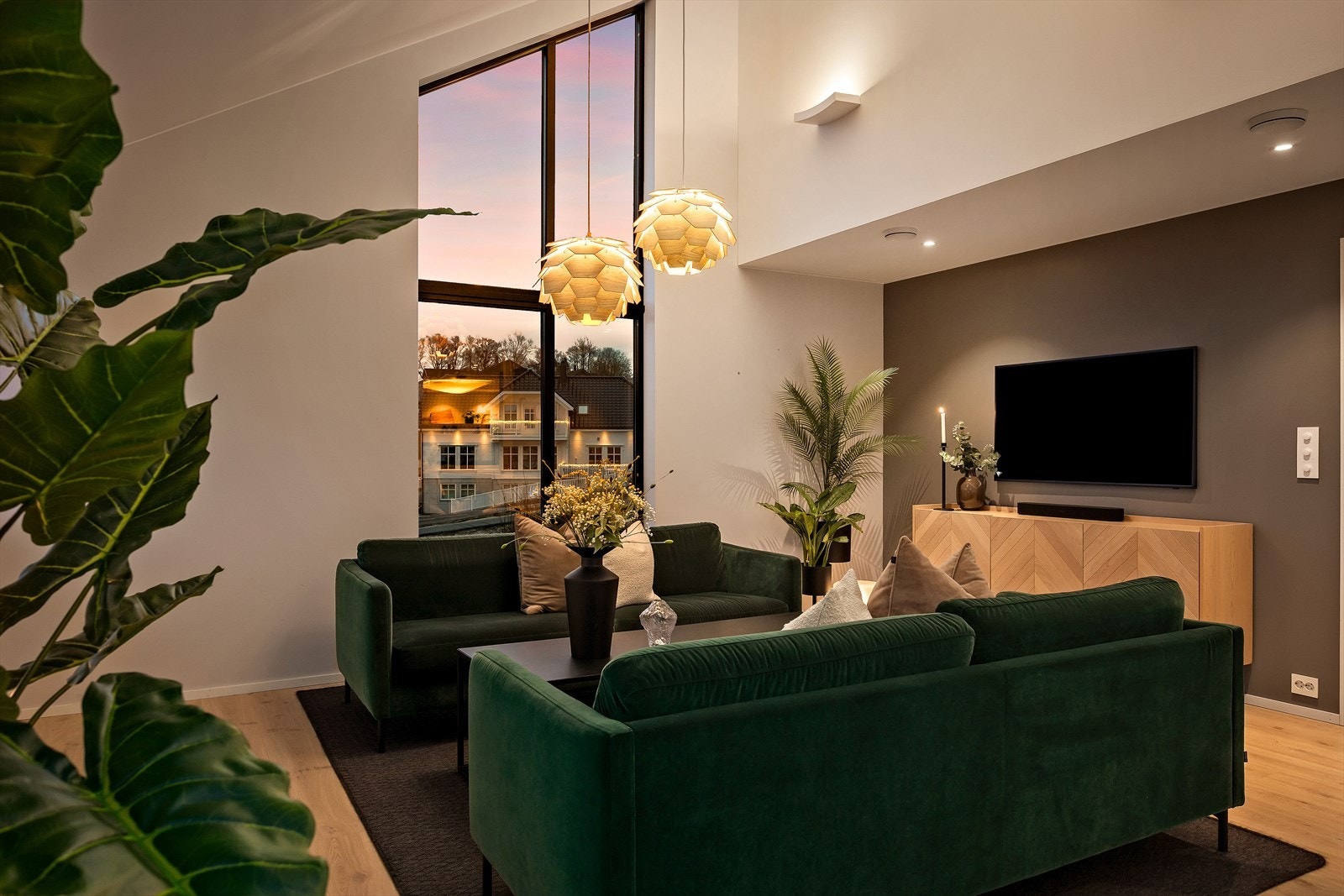 Boligens stue føles ekstra romslig med høy himling og store vinduer som inviterer naturen inn. Galleribilde