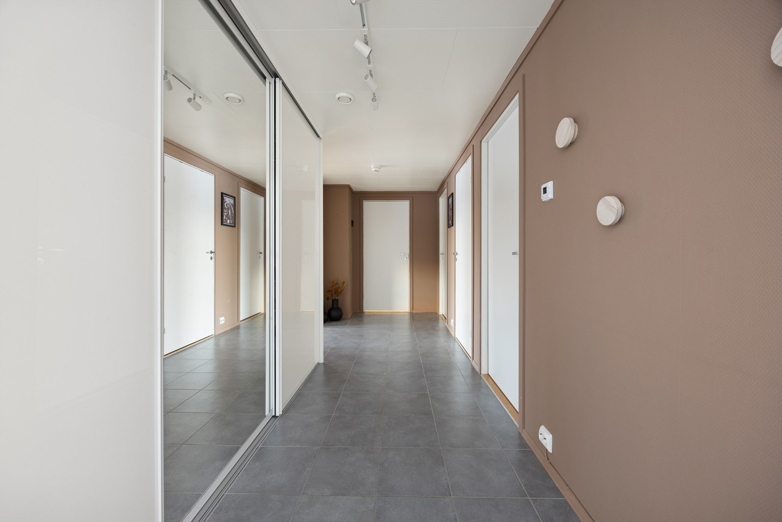 Romslig entré med flislagt gulv og en stor skyvedørsgarderobe med speilfronter for rikelig oppbevaring. Galleribilde