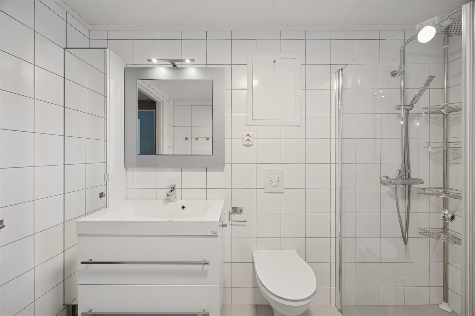 Baderomsinnredningen består av en servant med underskap og et speil med belysning. Galleribilde