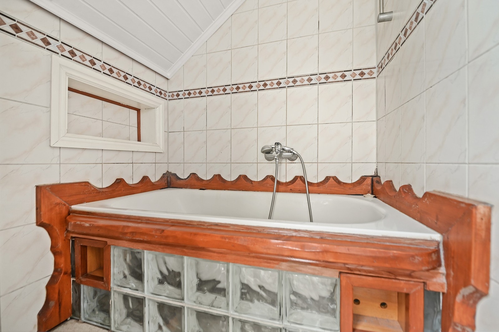 Badet har gulvstående wc, servantskap, speil, opplegg for vaskemaskin og badekar. Galleribilde