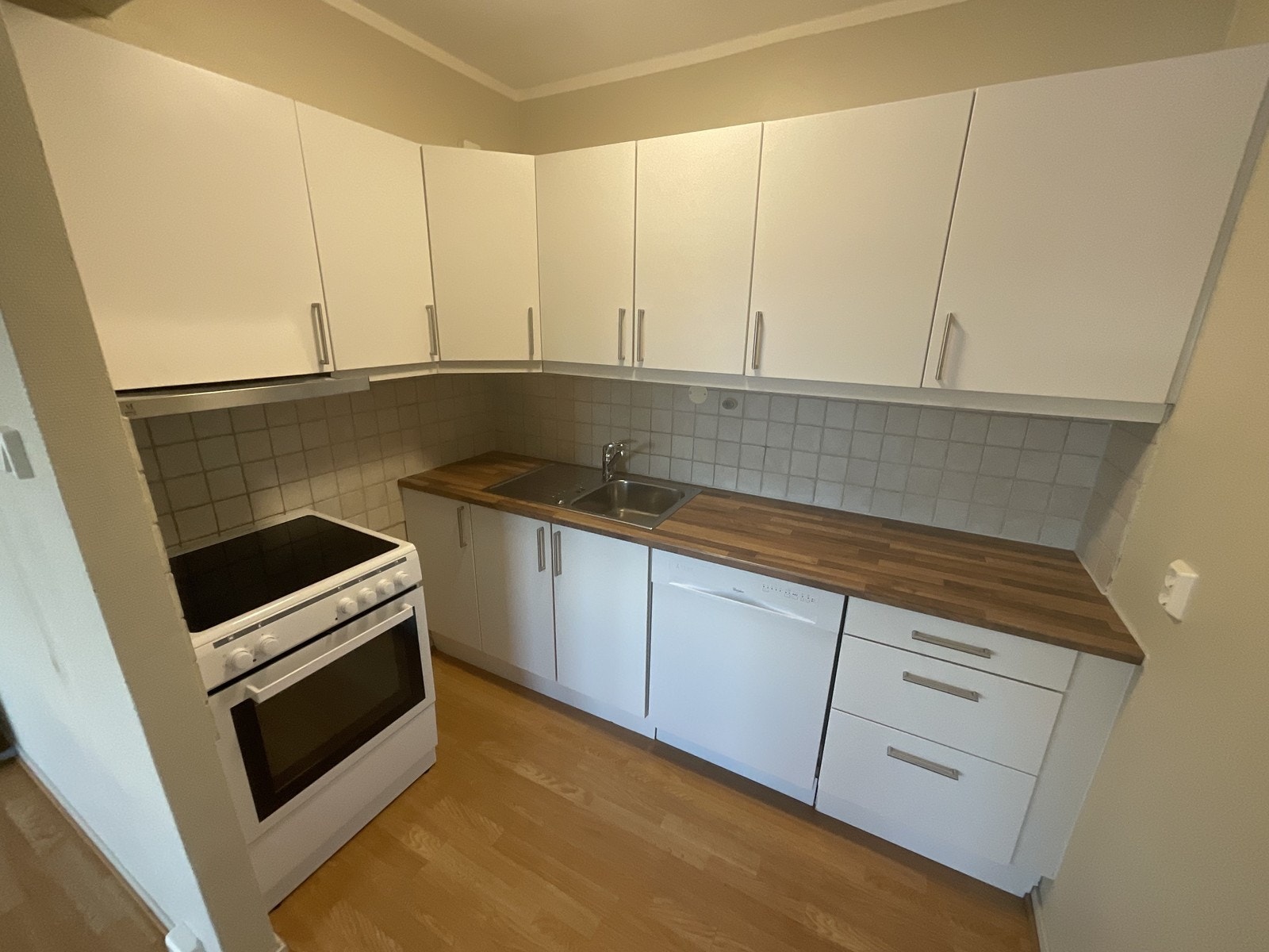 Kjøkken. Hvitevarer: komfyr og oppvaskmaskin. Galleribilde