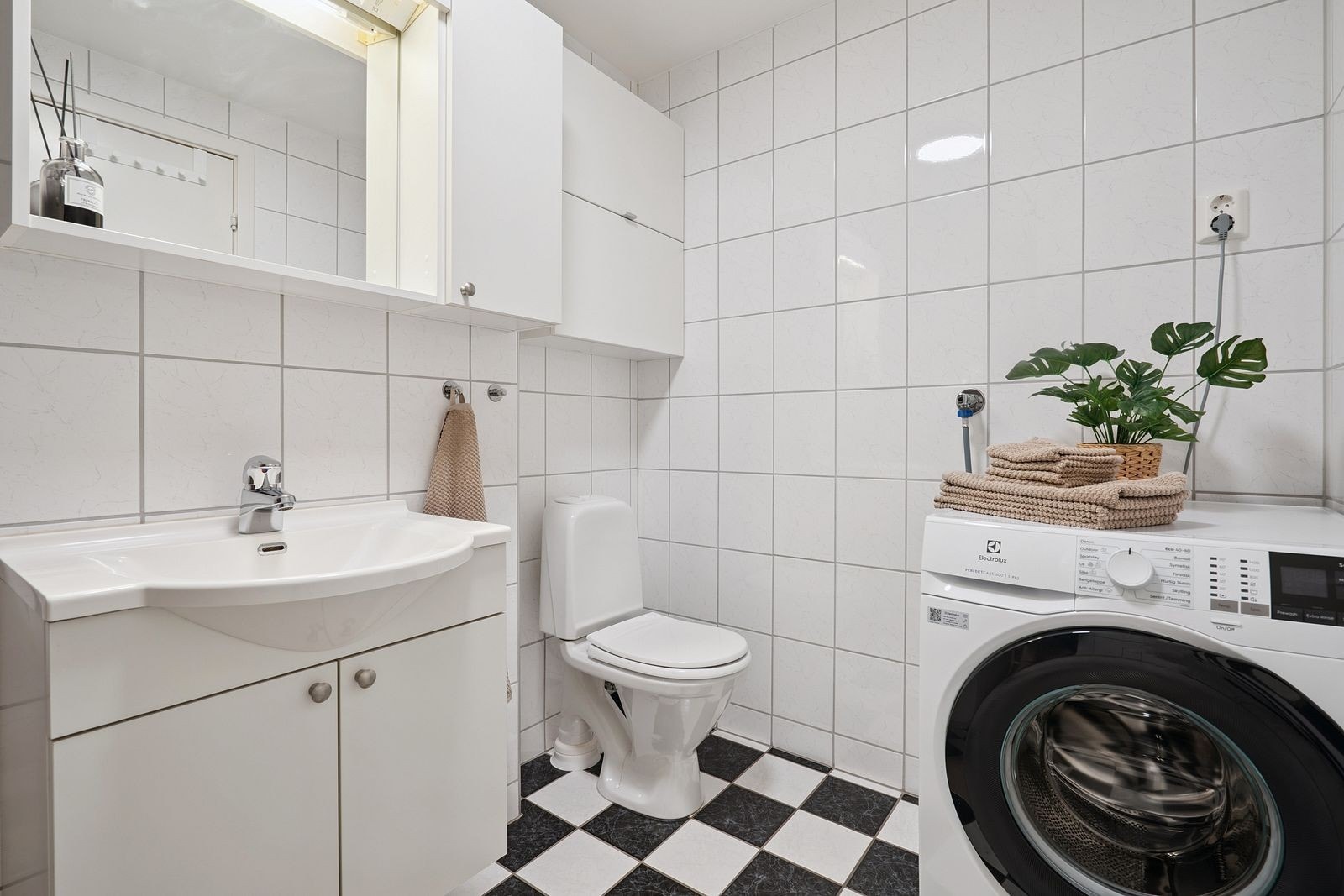 Praktisk bad med servant og over- og underskap, samt plass til vaskemaskin. Galleribilde