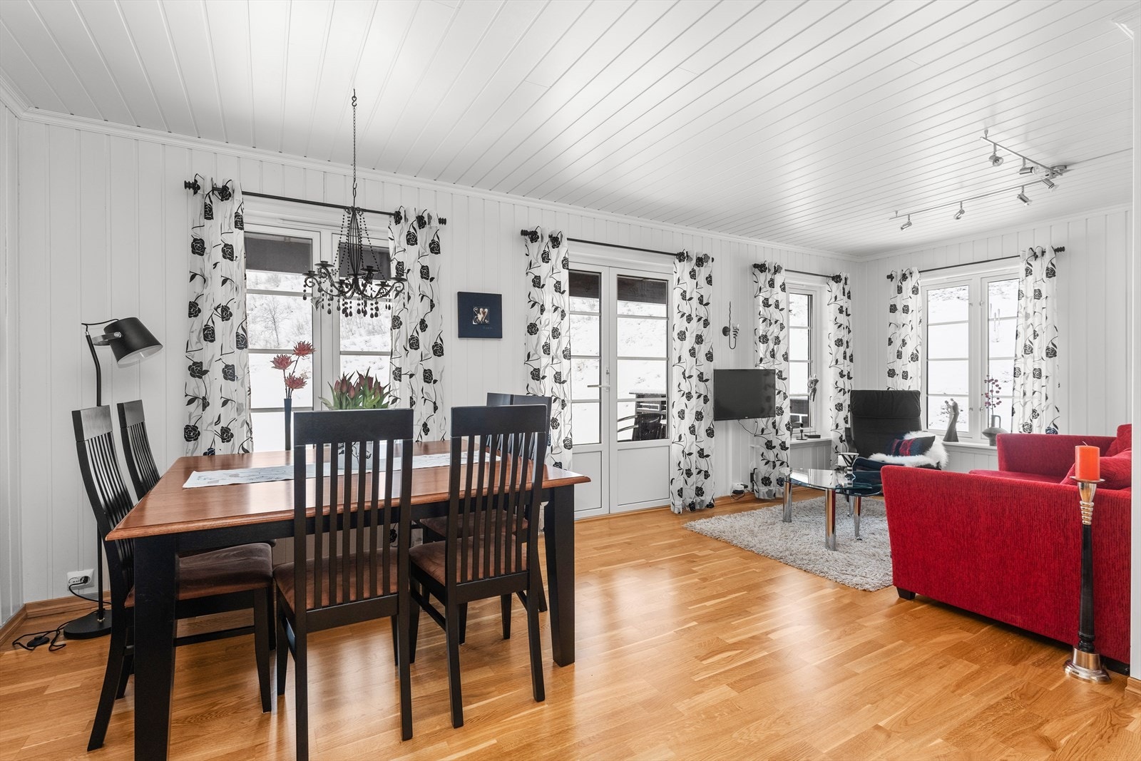 Stuen er lys med vinduer fra på to sider og utgang til terrasse foran leiligheten Galleribilde