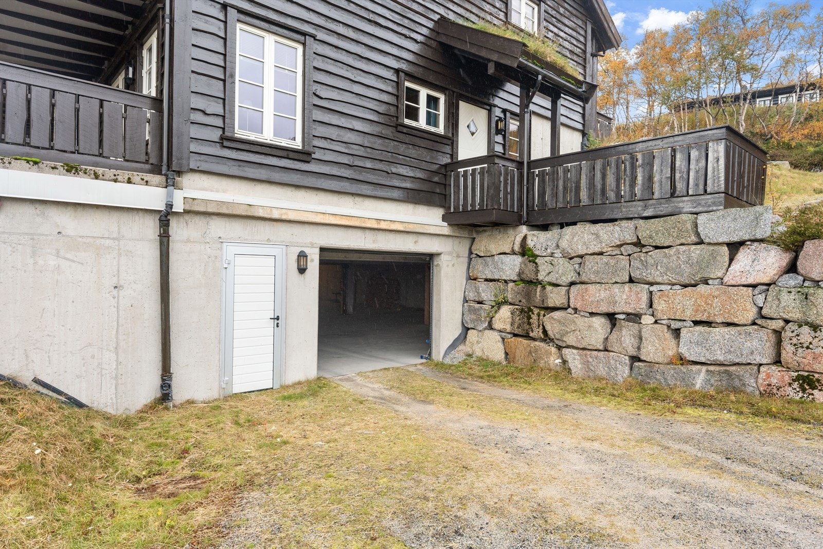 Innkjøring til garasjen med elektrisk port - her er det en stor bod med god plass til ved og fjellutstyr Galleribilde