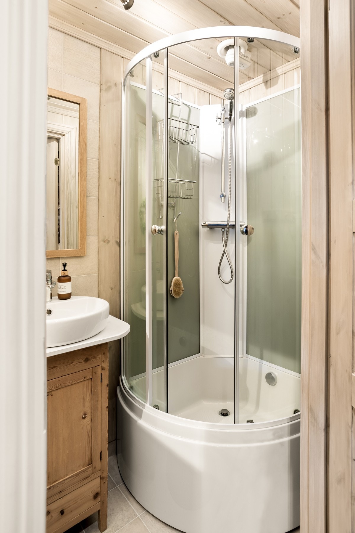 Det andre badet i 1. etasje er utstyrt med dusjkabinett, servant m/innredning og toalett. Galleribilde