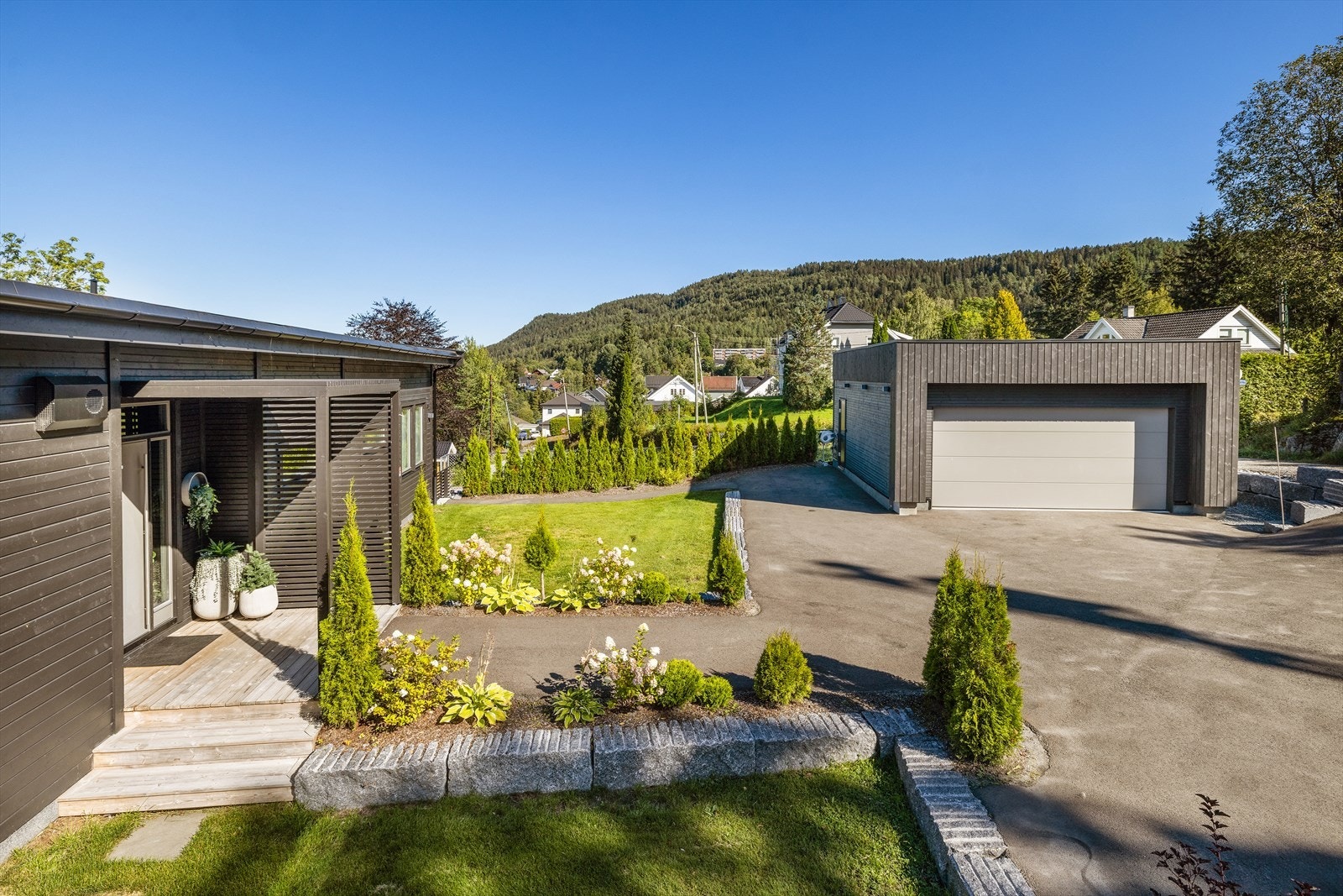 Tomten er opparbeidet med gressplen og beplantninger. Asfaltert innkjørsel og gårdsplass. Galleribilde