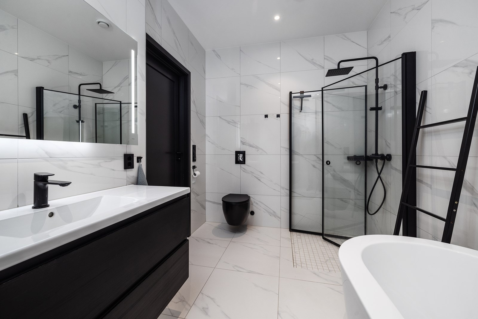 Det tredje badet som tilhører hoveddelen ligger i underetasjen og har klassiske 60X60 fliser i marmorutførelse med varmekabler i gulv og downlights i tak. Galleribilde