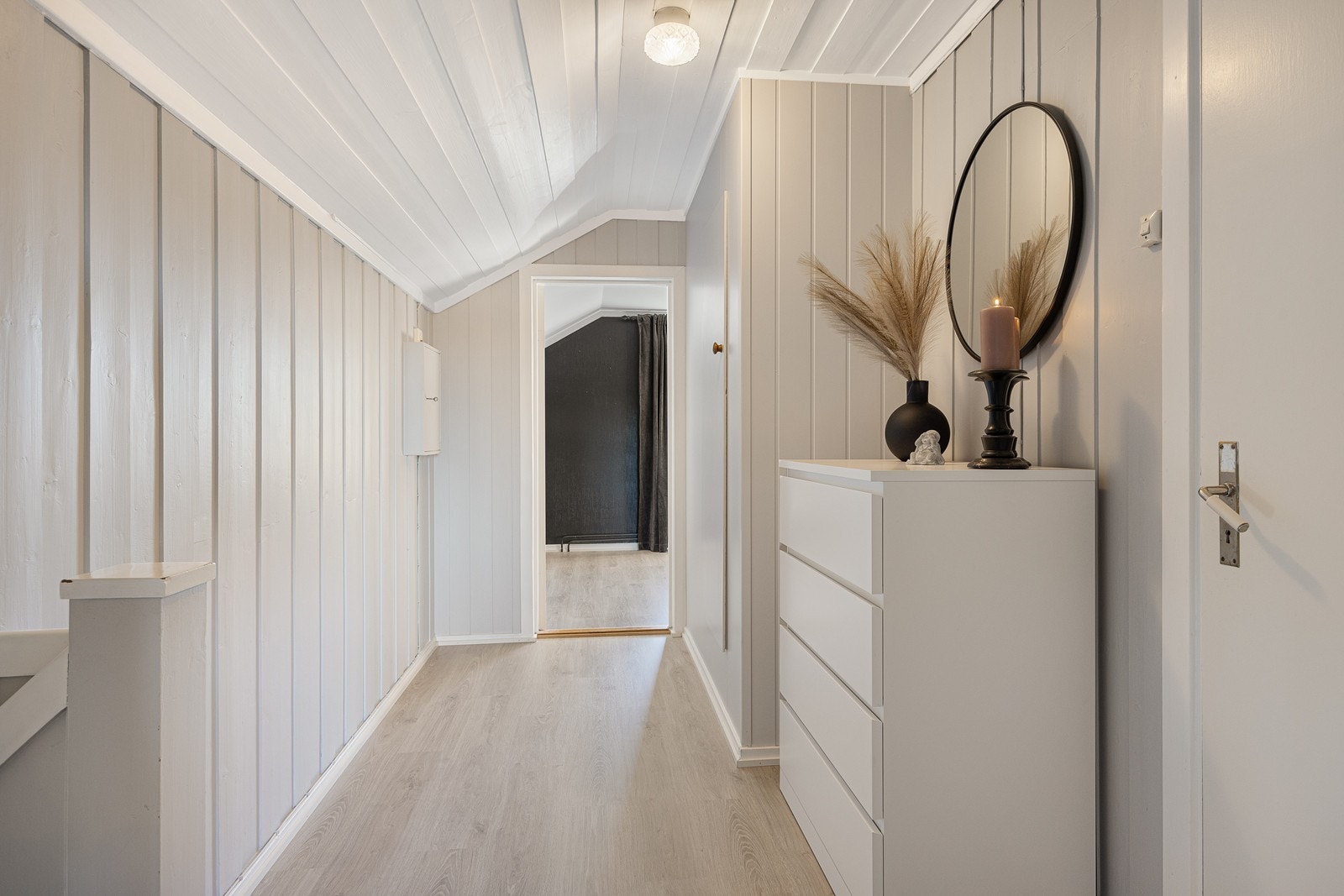 Fra trappeløpet i 1. etasje kommer man opp i denne hyggelige gangen i 2. etasje med plass til ulike garderobeløsninger. Galleribilde