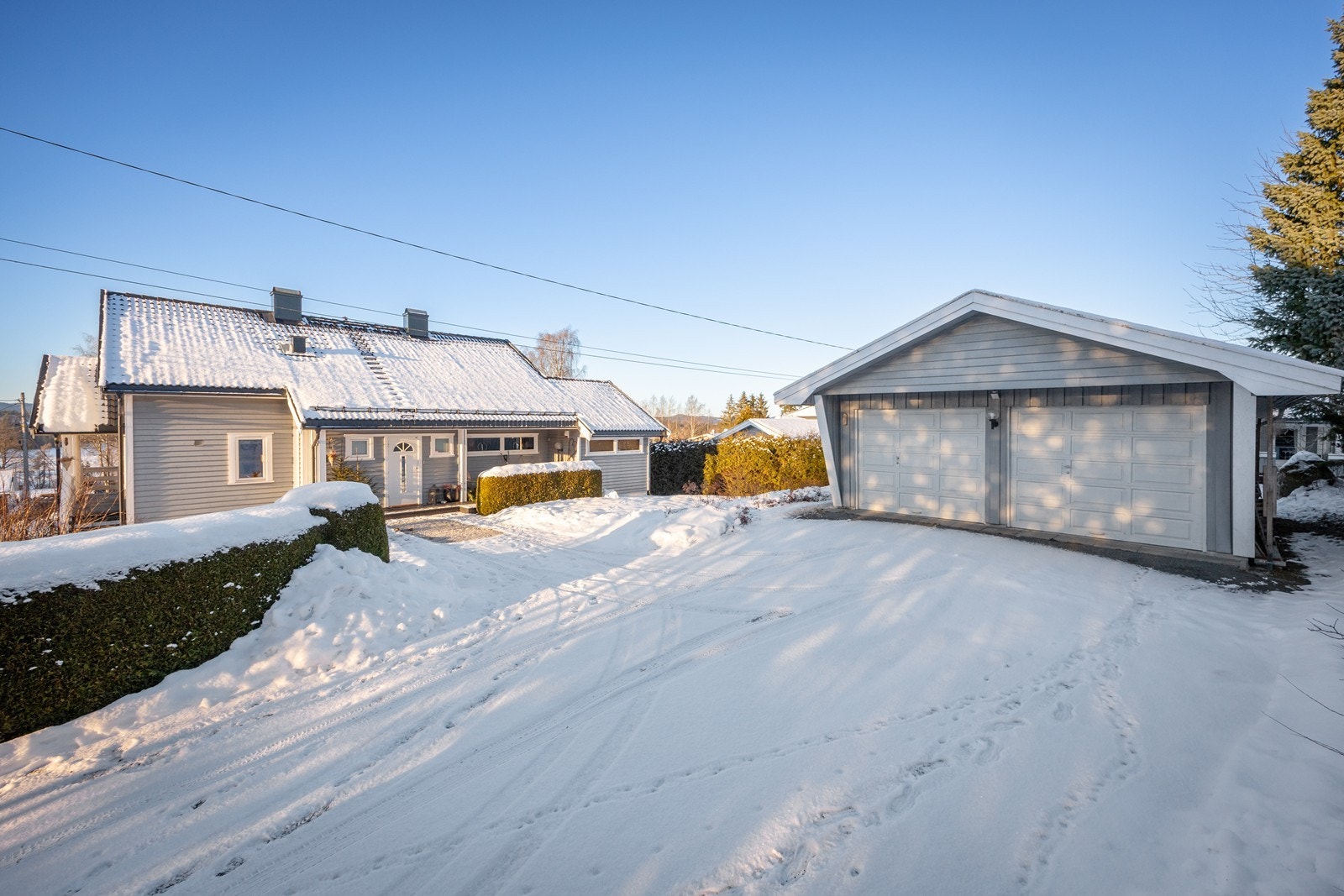 Det er parkering i en frittliggende dobbelgarasje, i en garasje i boligens kjeller og på en gruslagt gårdsplass. Galleribilde