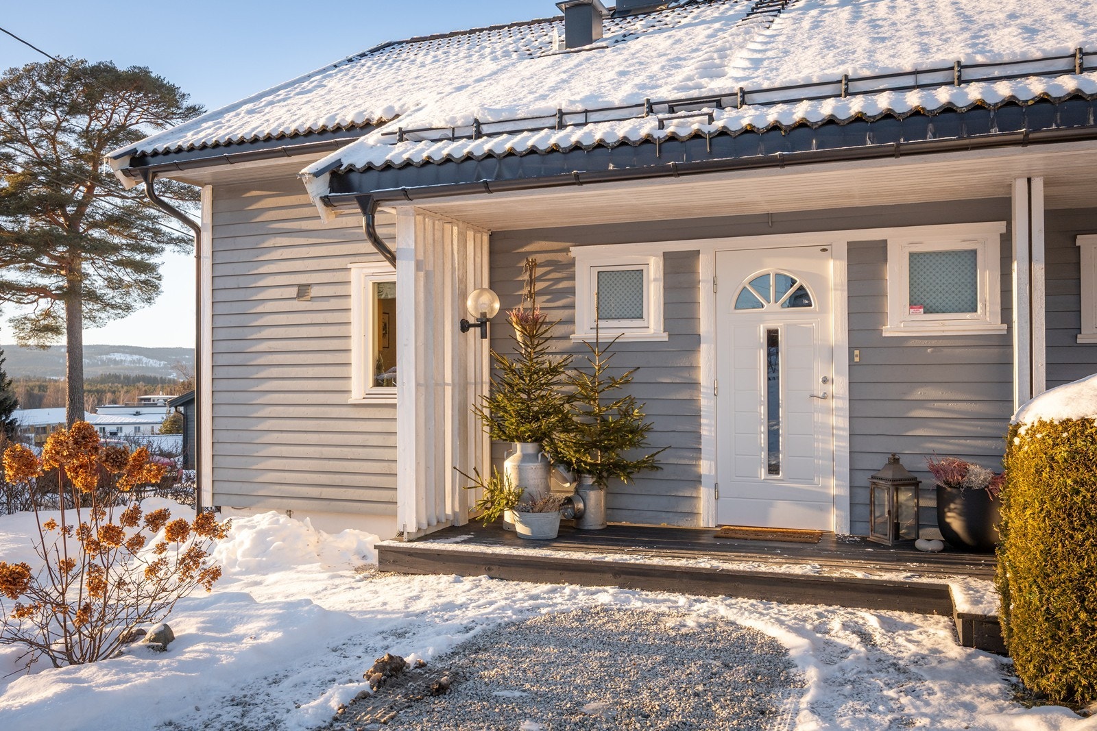 Eneboligen har et pent, overbygd inngangsparti med gruslagt adkomst, repos i tre og veggmontert utebelysning. Galleribilde