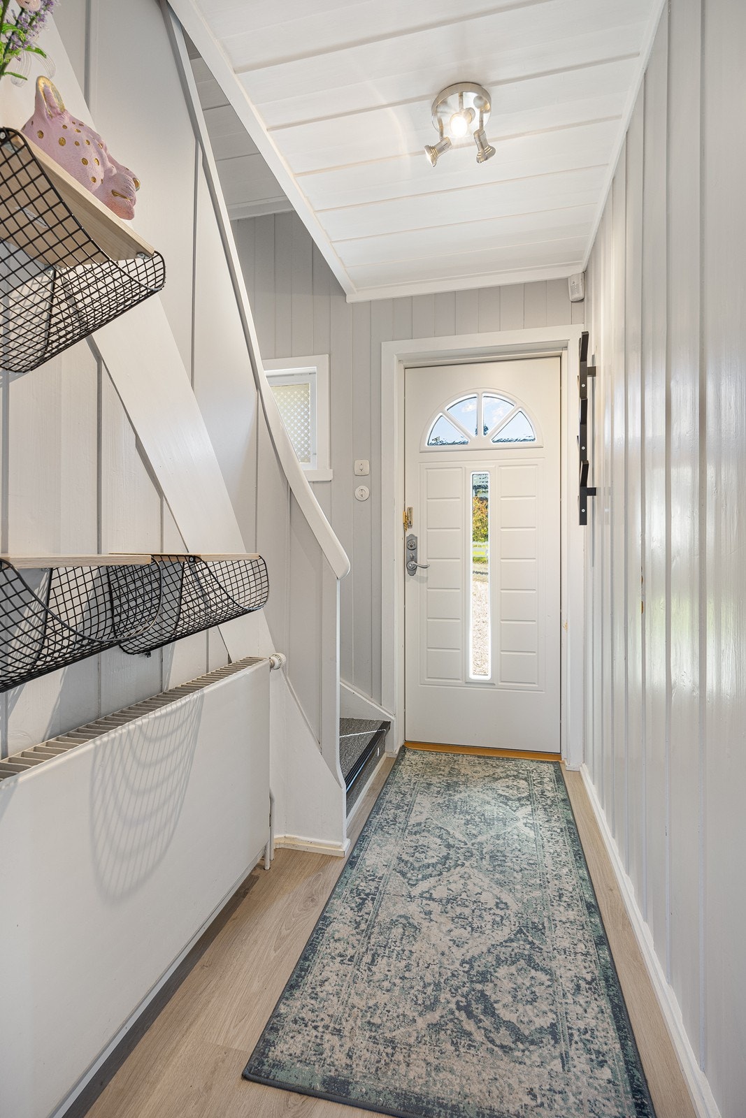 Vel inne blir vi ønsket velkommen i en fin entré med lysmalte vegger og tidsmessig laminat på gulvet. Galleribilde