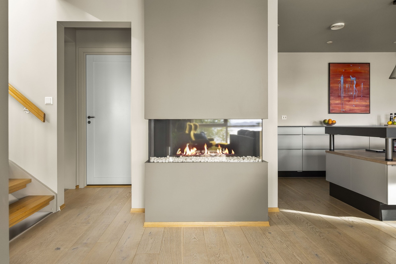 Peisen glir sømløst inn i interiøret, plassert slik at stemningen nytes fra hele rommet. Galleribilde