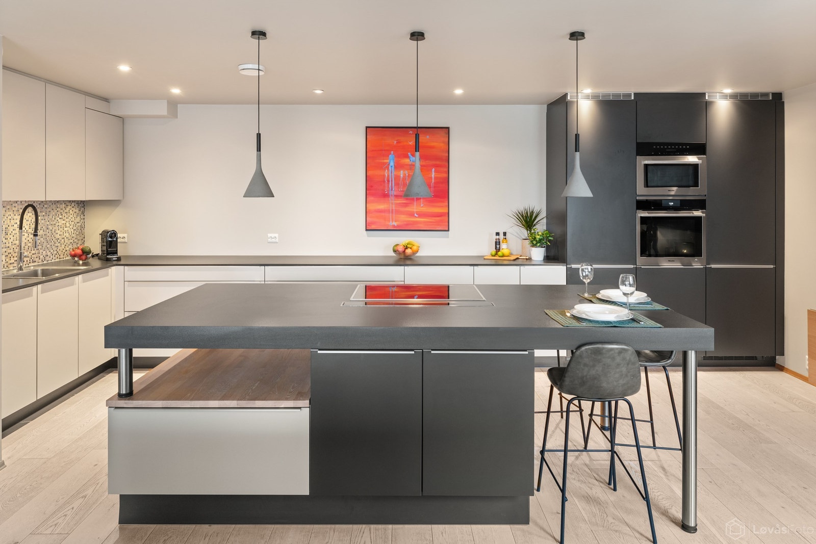 Kjøkkenet har en funksjonell L-form med gode arbeidsflater suppleres av en flott kjøkkenøy med platetopp for sosial matlaging. Galleribilde