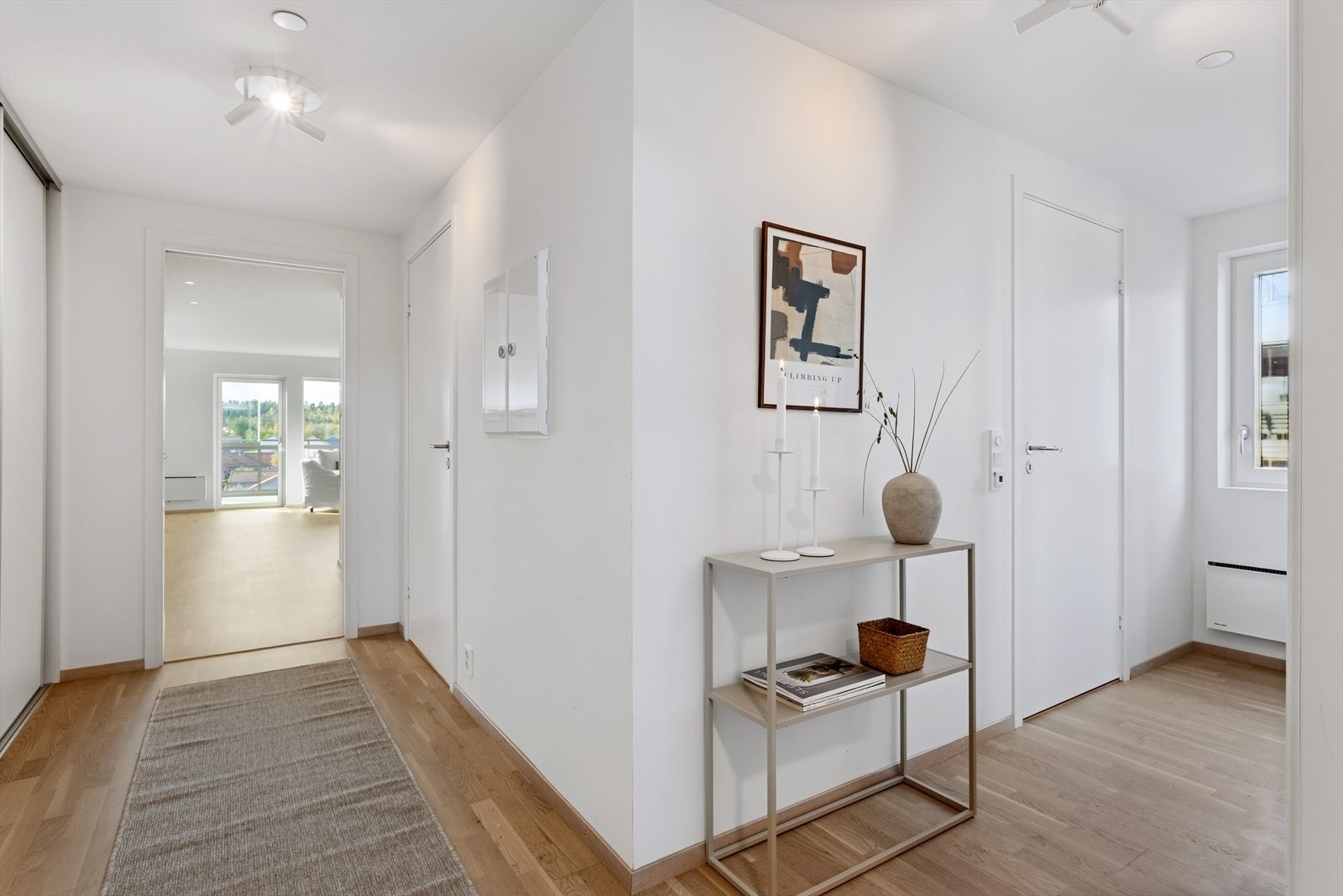 Vel innenfor leiligheten inngangsdør, møter man den hyggelige entreèn og gangen som ønsker deg og dine gjester velkommen inn. Rommet er adskilt med skyvedør inn til stue-/kjøkkensonen. Galleribilde