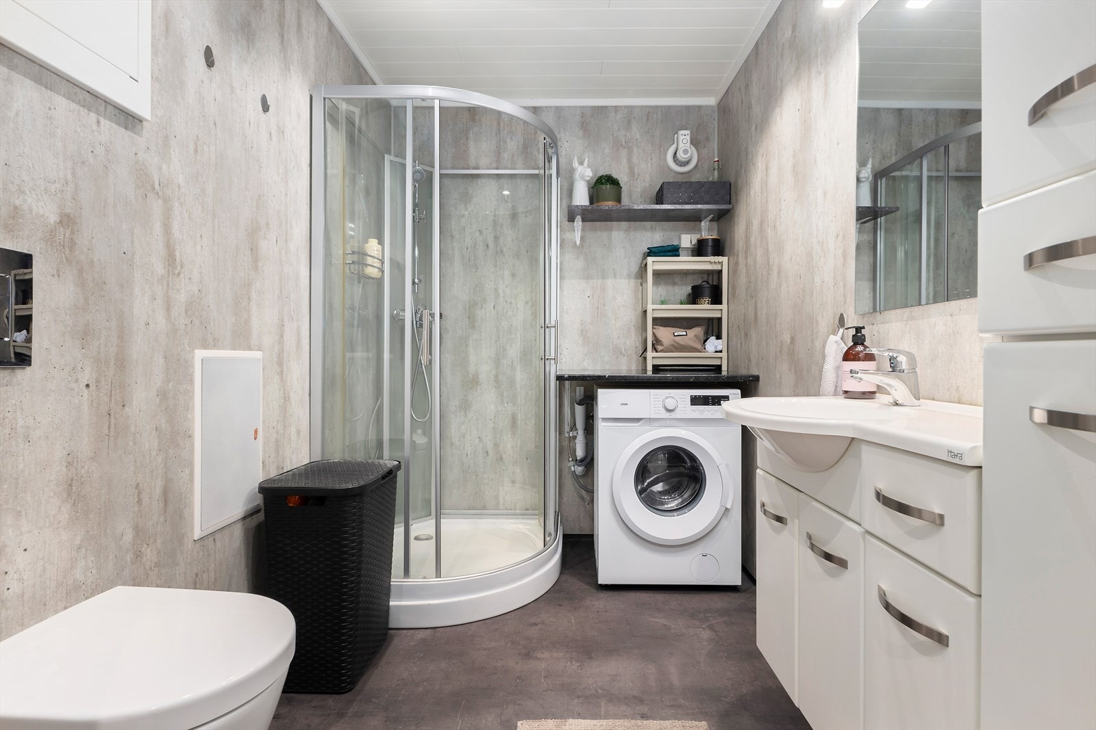 Bad/wc/vaskerom i 1.etasje. Dette badet er modernisert og har varmekabler i gulvet, vegghengt wc, dusjkabinett og innholdsrik baderomsinnredning. Galleribilde