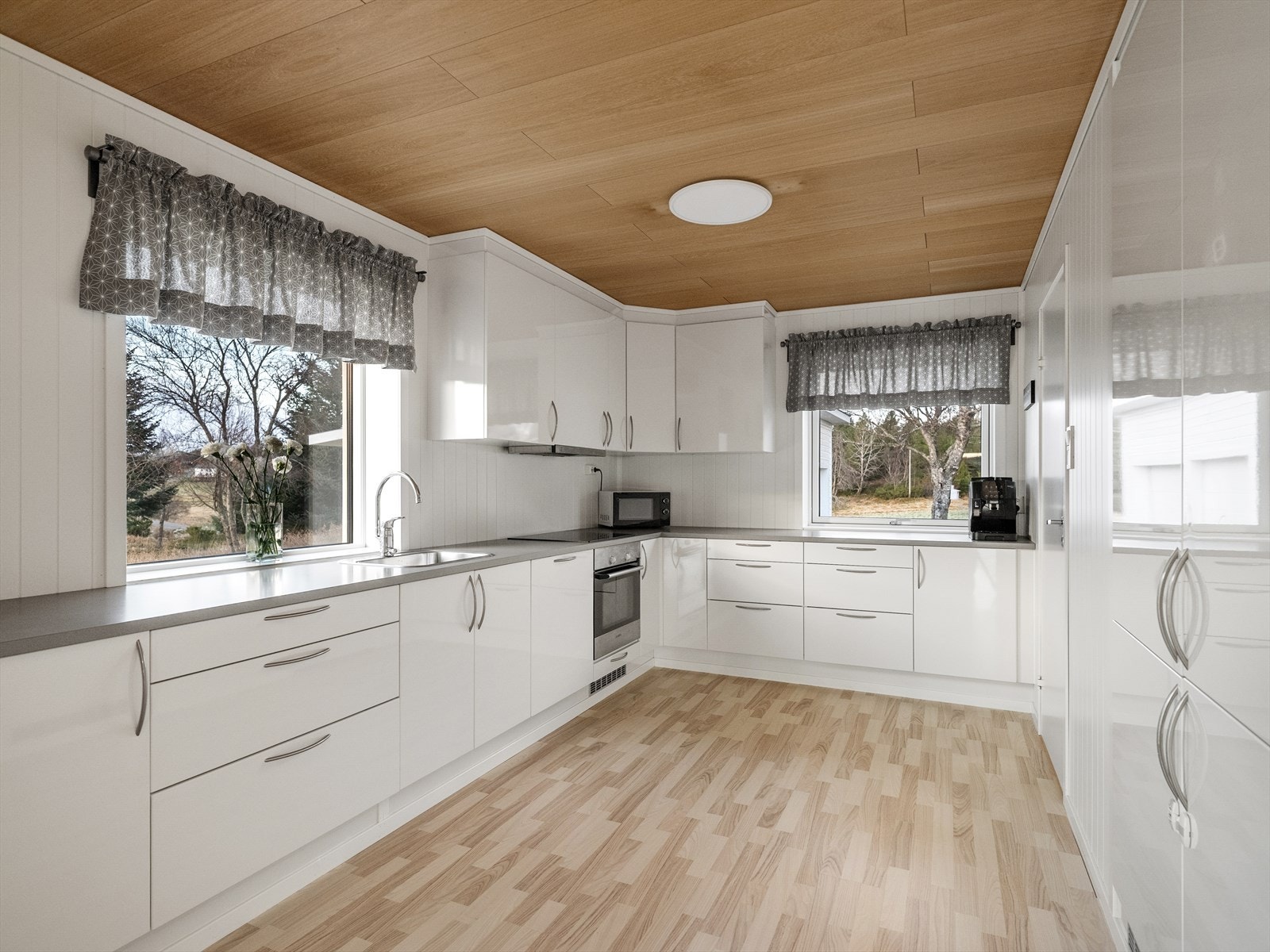 Moderne kjøkken med god benkeplass og integrerte hvitevarer Galleribilde