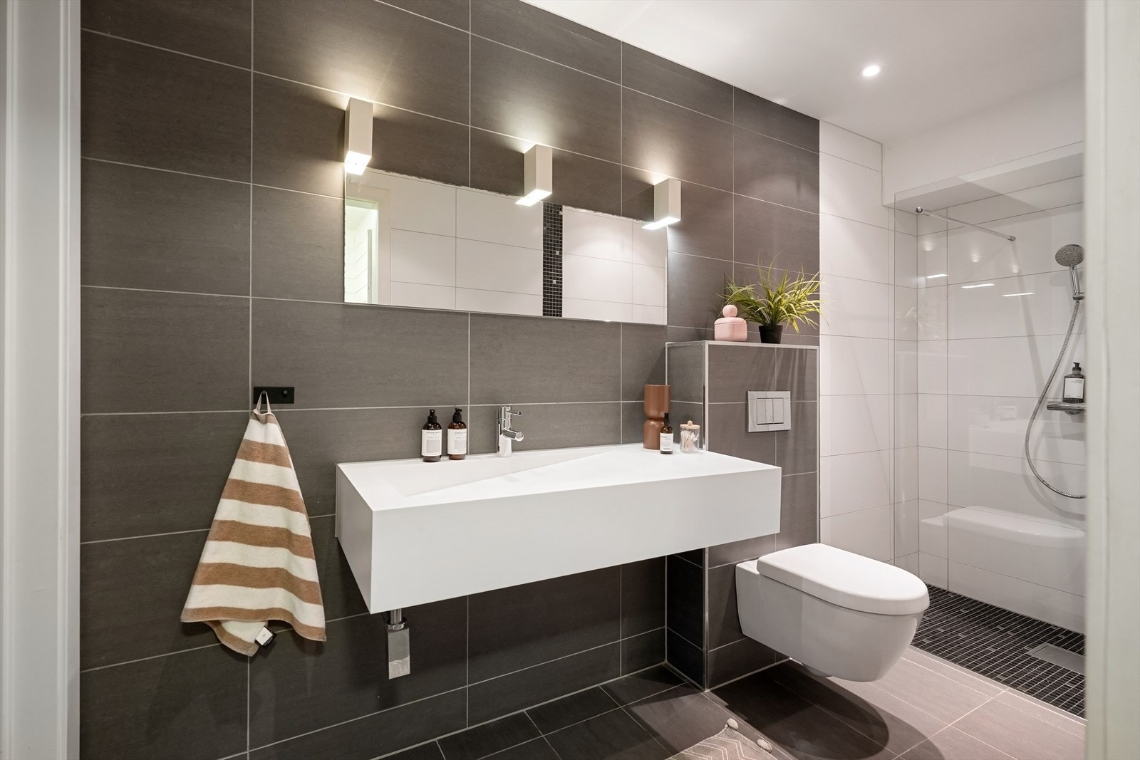 Bad, sist ble pusset opp i 2013, med direkte adkomst til både badstue og bassengrom. Badet har fliser i 30 x 60 cm på vegger og gulv. Gulvet har varmekabler, og belysningen består av spotter i tak samt vegglamper over speil som skaper en lun atmosfære. Galleribilde