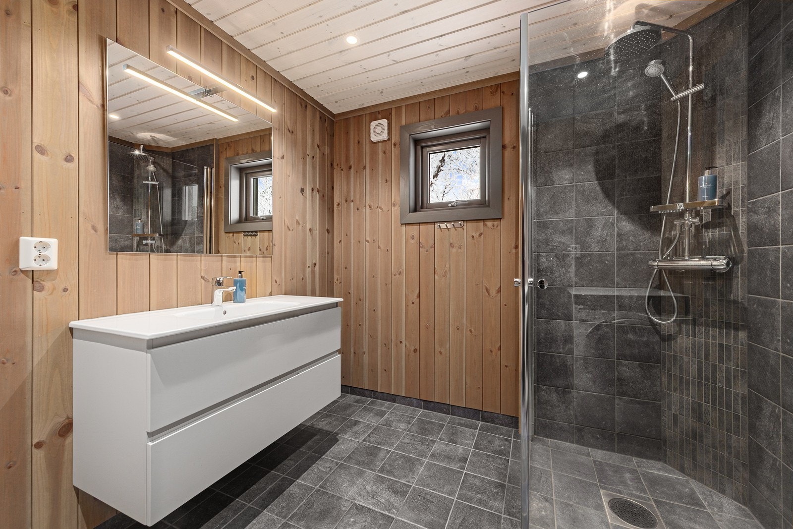 Hovedbad med dusjhjørne, servant, wc og opplegg for vaskemaskin Galleribilde