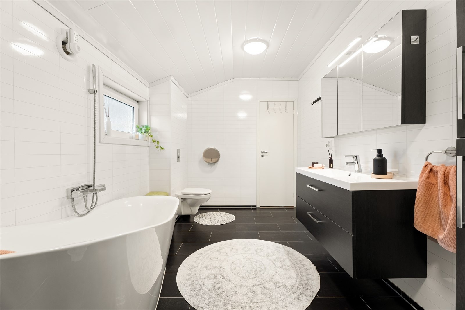 Moderne bad med panel i taket, våtromsplater på veggene og behagelig gulvvarme for ekstra komfort. Galleribilde