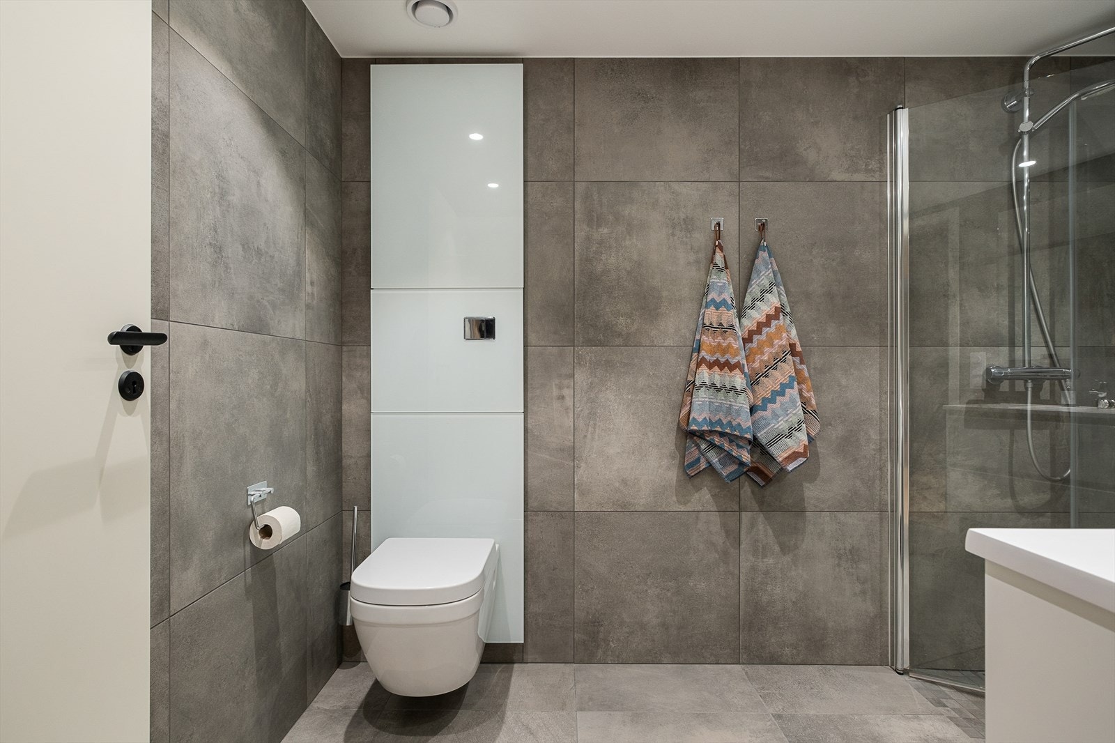 Lekkert bad med store 60x60 fliser, behagelig gulvvarme og opplegg for vaskemaskin. Galleribilde