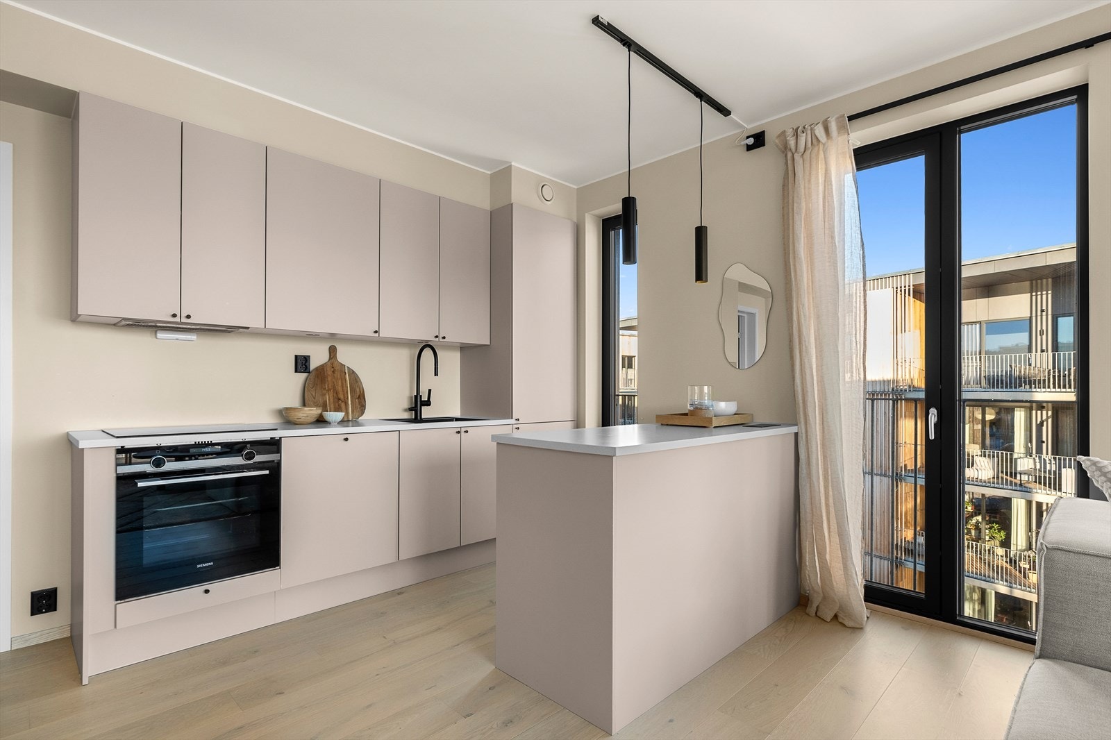 Stilrent og moderne kjøkken med integrerte hvitevarer og praktisk kjøkkenøy. Galleribilde