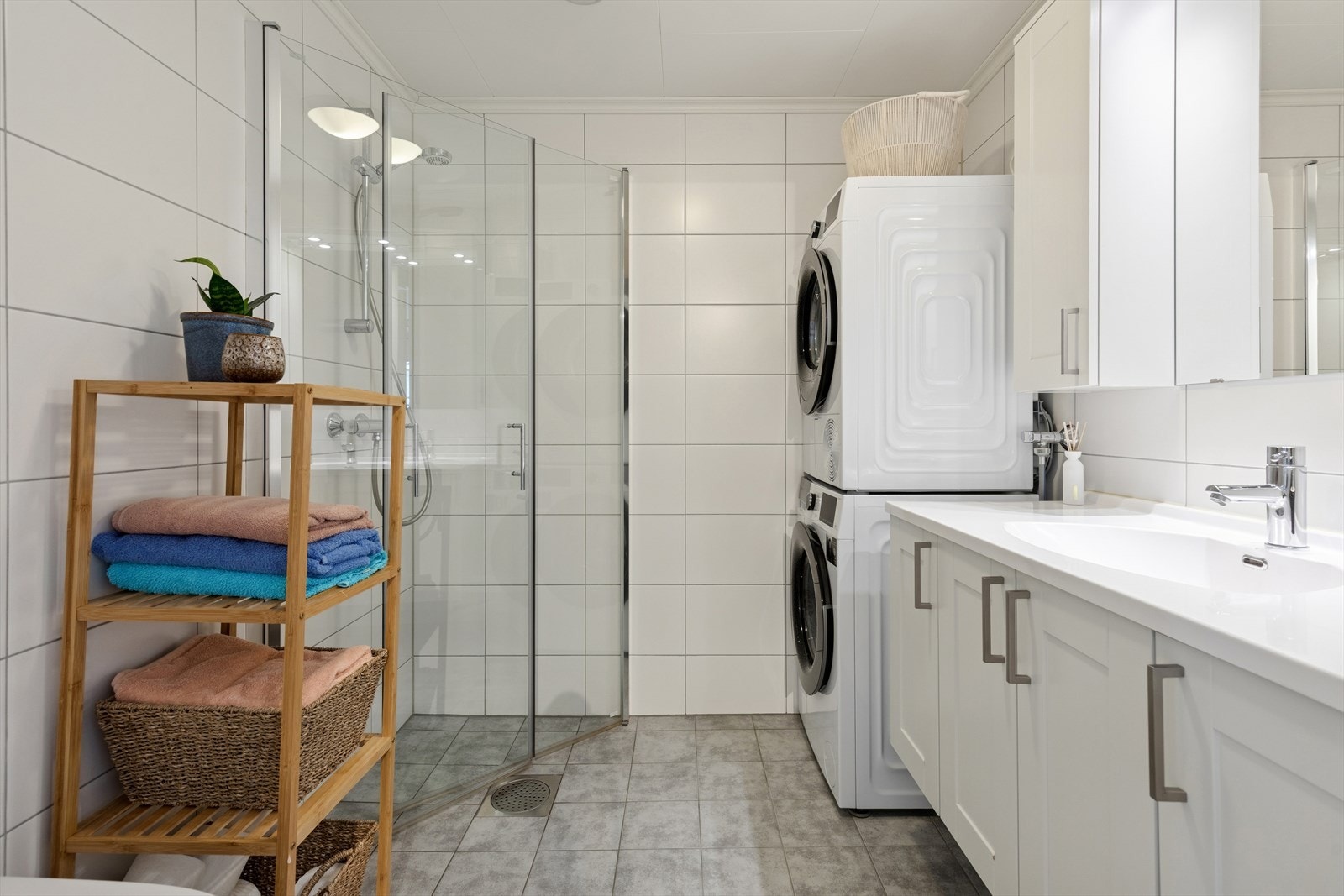 Badet er pent flislagt og har varme i gulvet, noe som gir en behagelig atmosfære. Det er innredet med servantinnredning, dusjnisje med innfeltbare glassdører, toalett, samt opplegg for vaskemaskin og tørketrommel i søyle. Galleribilde