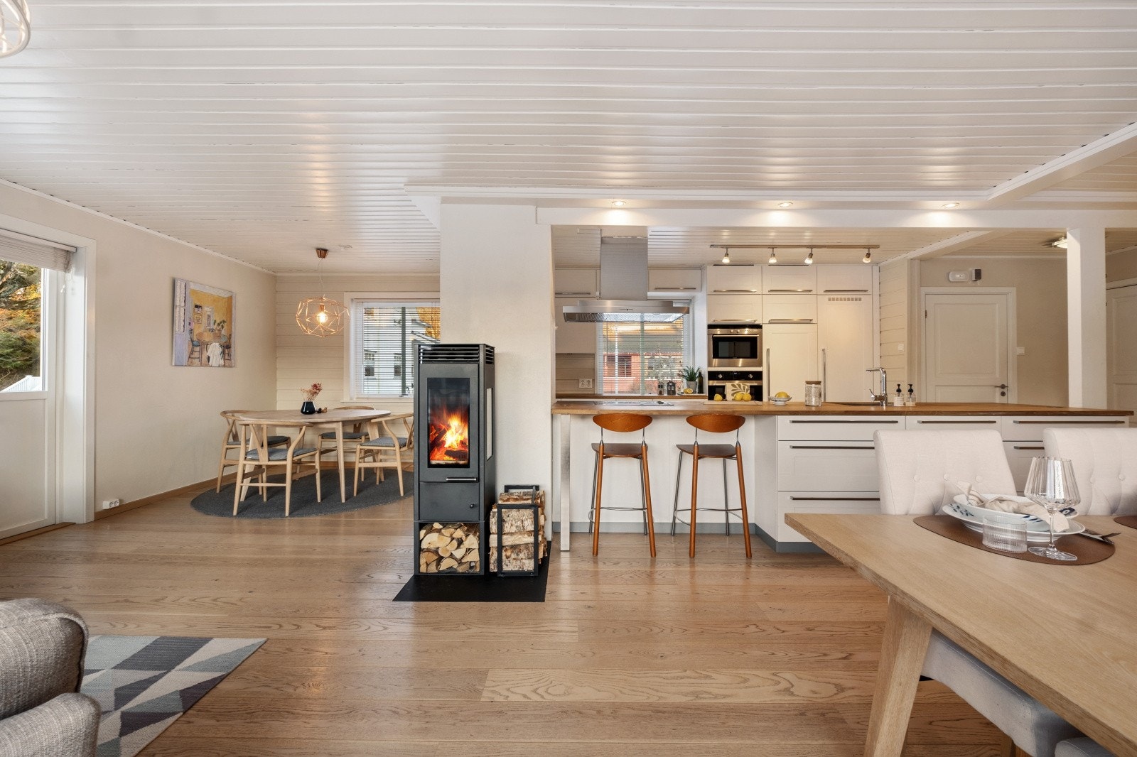 Rommet har ildsted som gir hygge og ikke minst rask oppvarming - I tillegg er det også her flere store vindusflater Galleribilde