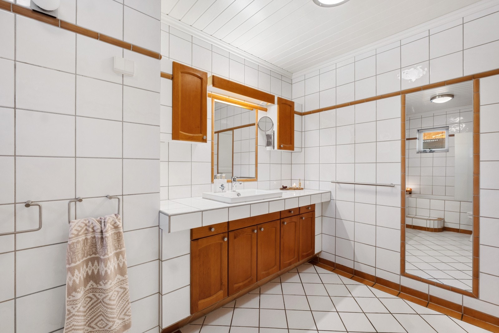 Innredningen består av innfliset benk med nedfelt servant med skap under, overskap og speil Galleribilde