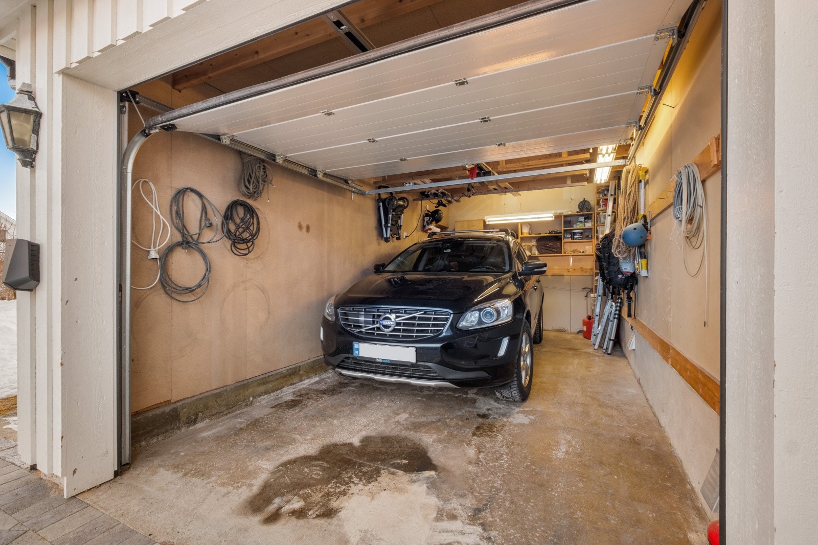 Garasje med lader for elbil på vegg utenfor Galleribilde