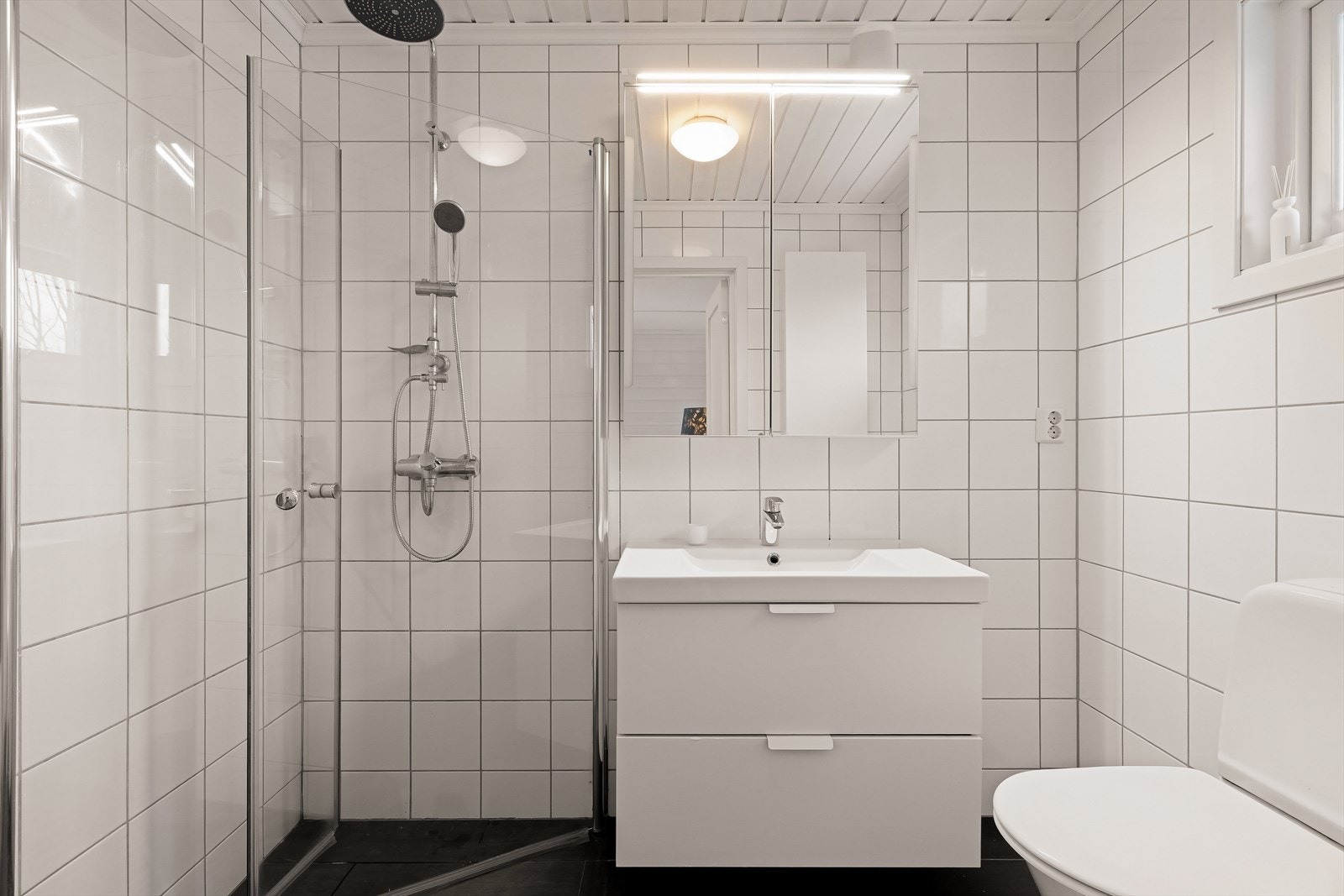 Dusjhjørne med glassvegger, servantskap, speilskap, klosett og høyskap Galleribilde