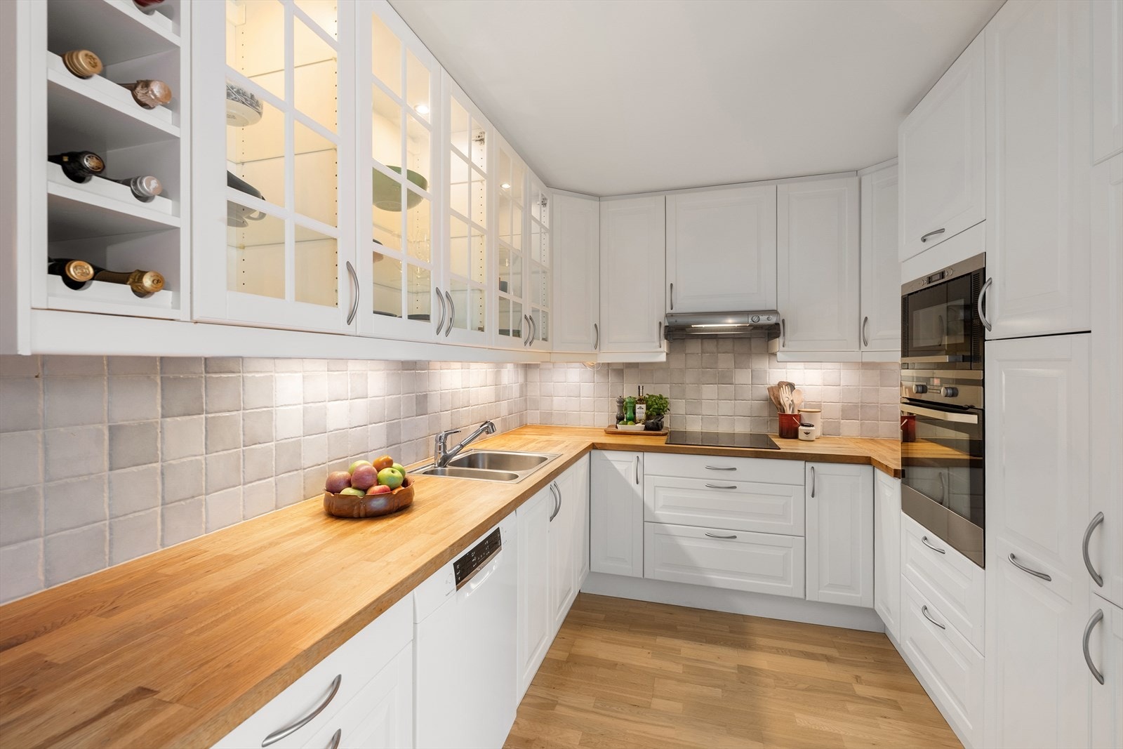 Kjøkkeninnredning med profilerte fronter samt heltre benkeplate som gir et varmt og tidløst uttrykk - Benkeplatene er lakkert i både 2021 og 2025 Galleribilde