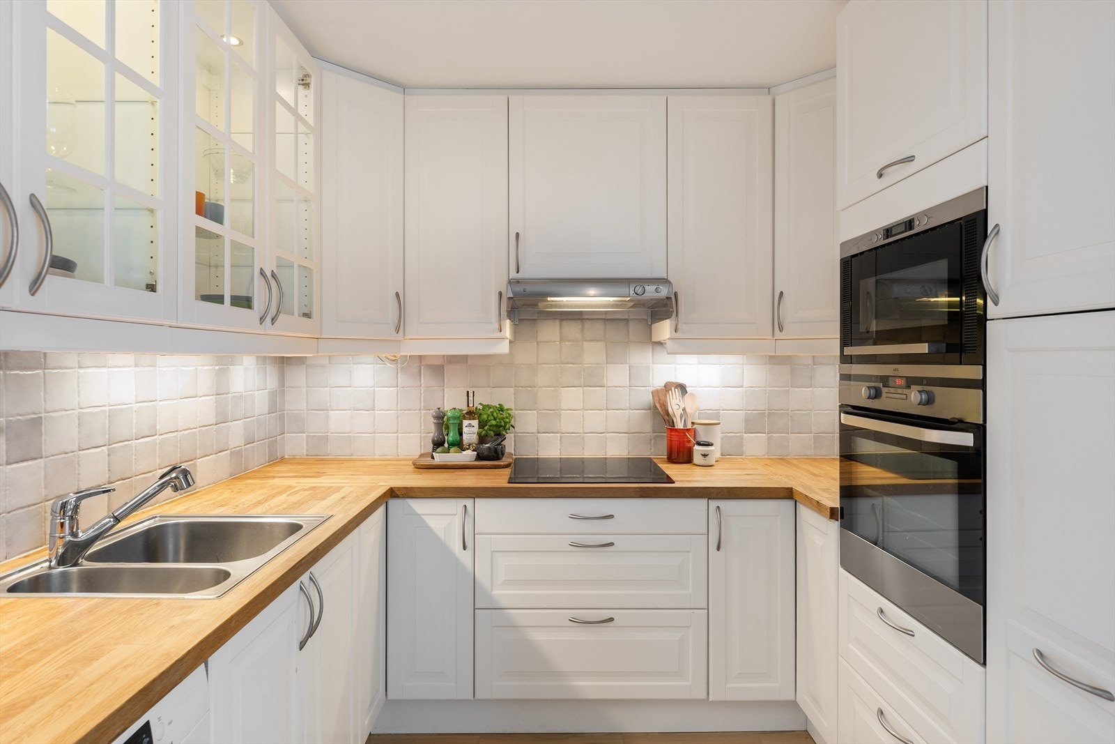 En praktisk og hyggelig kjøkkenløsning med god arbeidsplass og naturlig lys Galleribilde