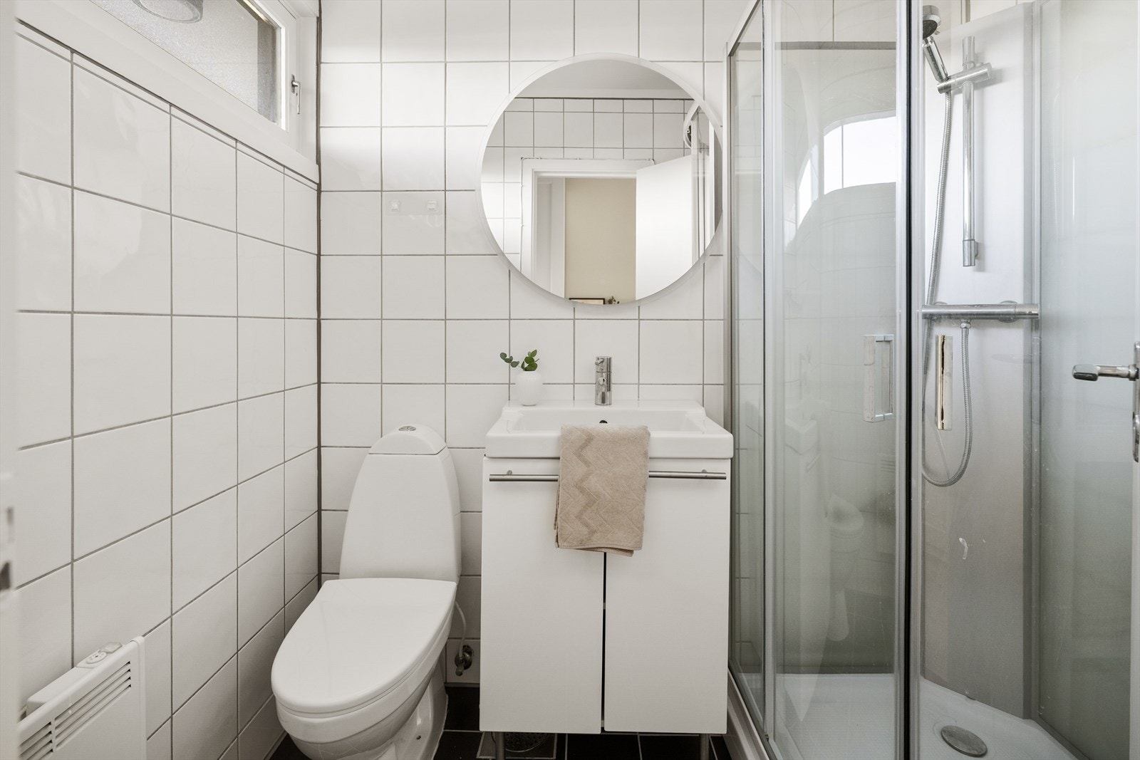 Helfliset bad, innredet med nedfelt servant i baderomsmøbel, toalett og dusjkabinett. Galleribilde