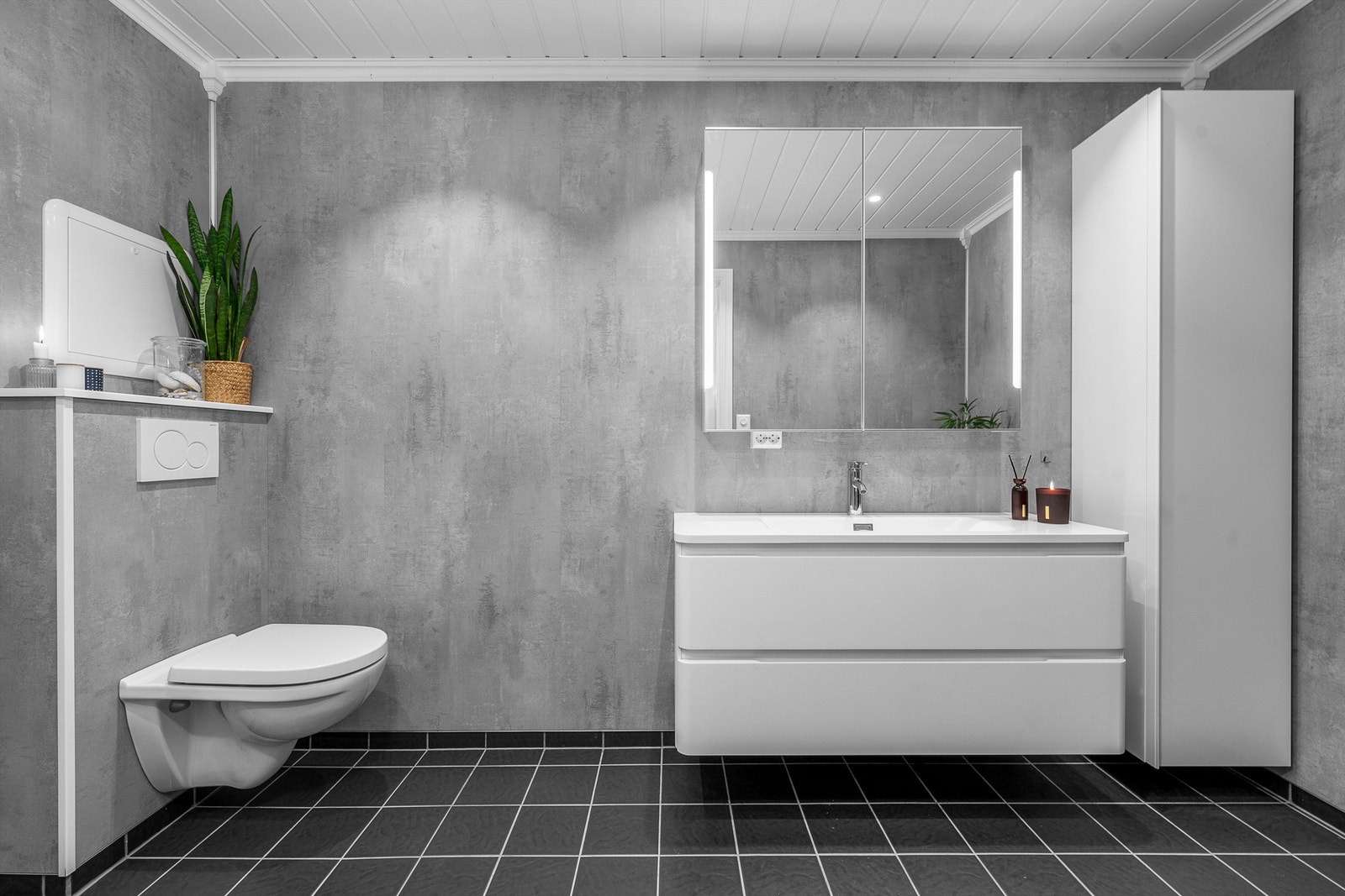 Vegghengt servantskap med heldekkende servant og ett-greps armatur. Speilskap over servant med overlys. Innebygget sisterne med vegghengt klosett. Galleribilde